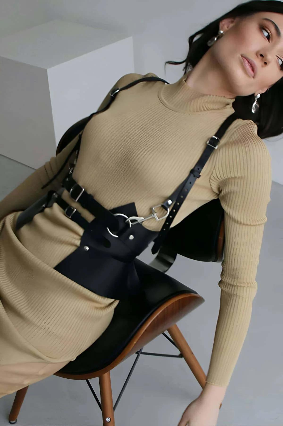 Side view of black faux leather harness showing O-ring chest junction and adjustable shoulder straps