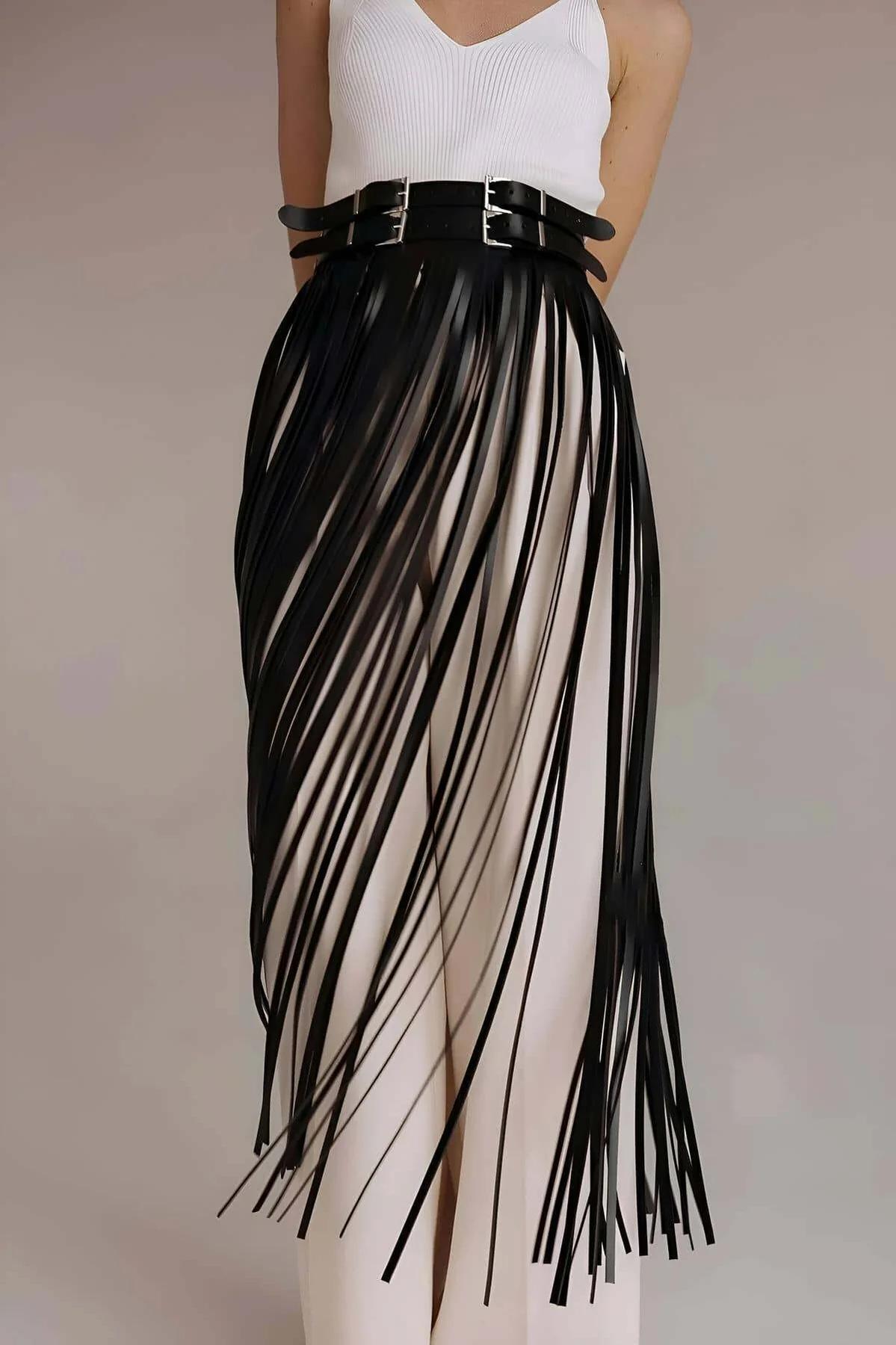 Close-up of dual silver-tone pin buckles on wide black faux leather waistband of fringe overlay