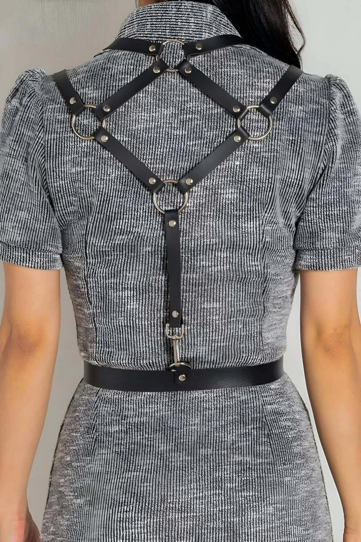 close-up of silver pin buckle and O-ring detail on black PU leather harness strap