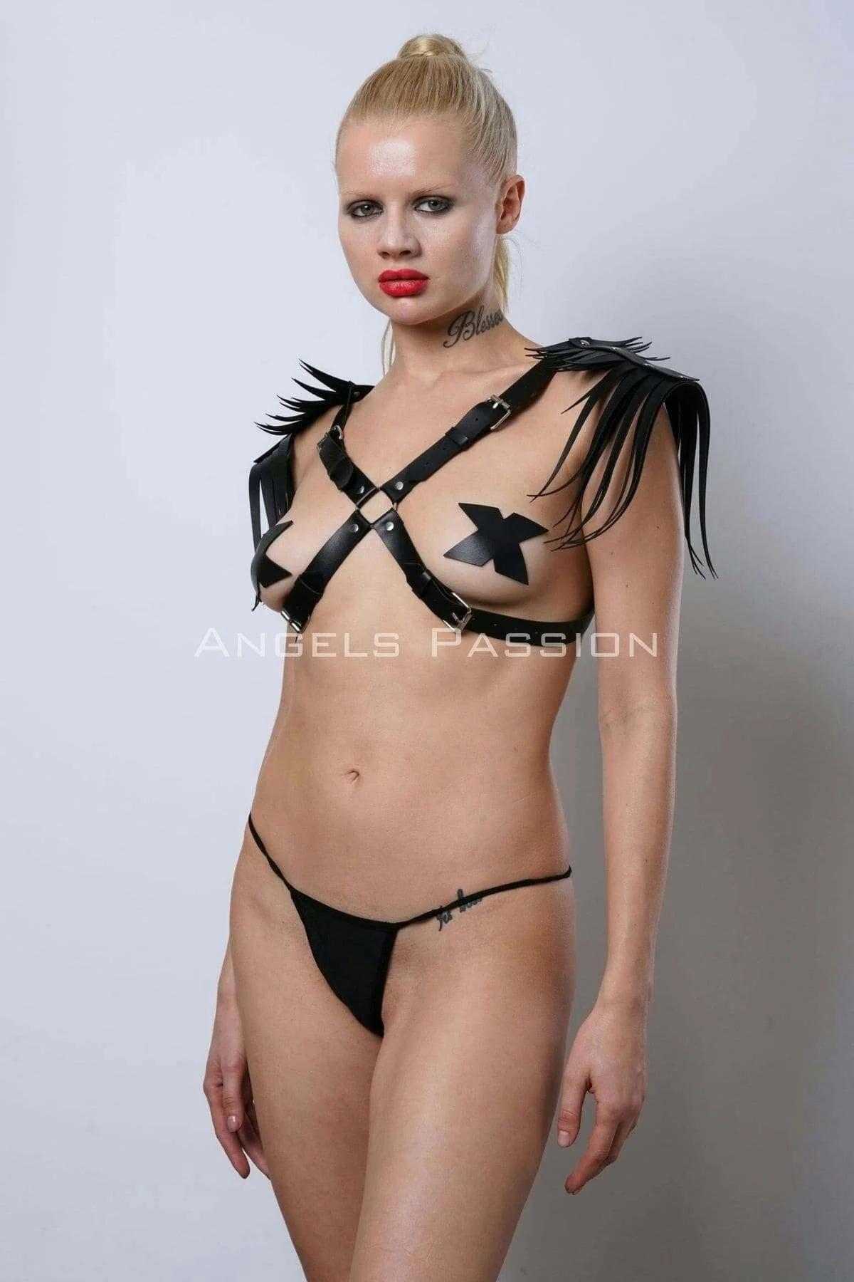 Close-up of silver snap fasteners and fringe fringe detail on black shoulder harness