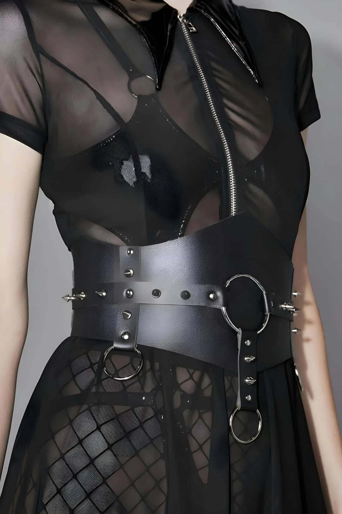 Close-up of silver spike rivets and 4 cm O-ring on black pebble-grain faux leather waist band
