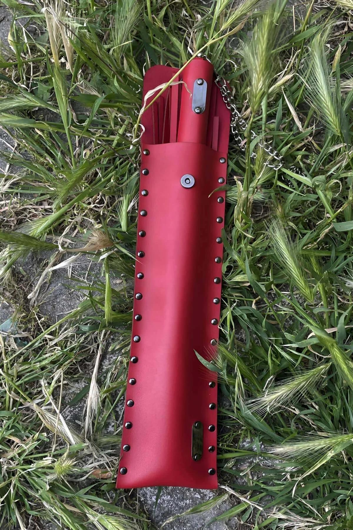 Bright red faux leather fringe tails fanned out from silver-tone chain handle close-up detail