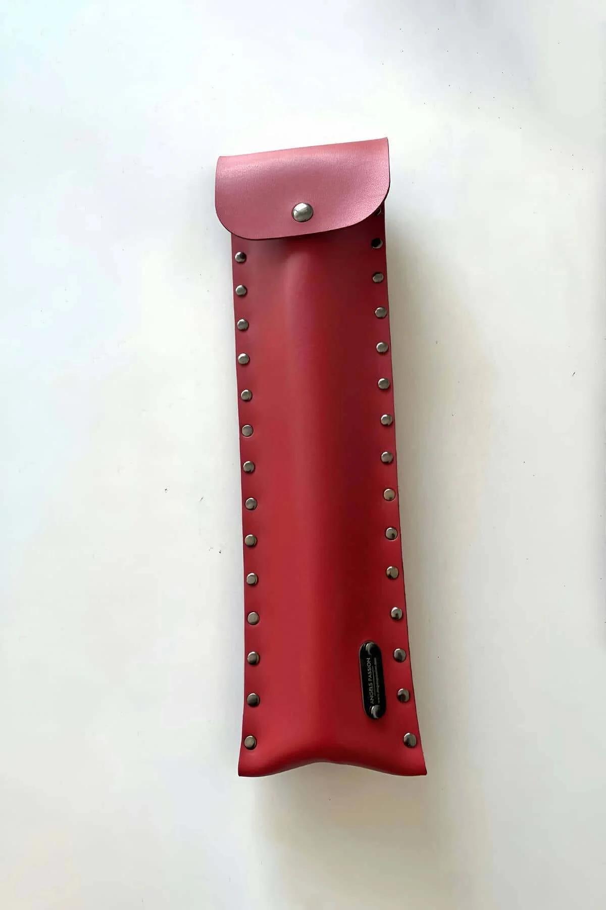 Red faux leather fashion flail coiled inside matching studded pouch for compact storage