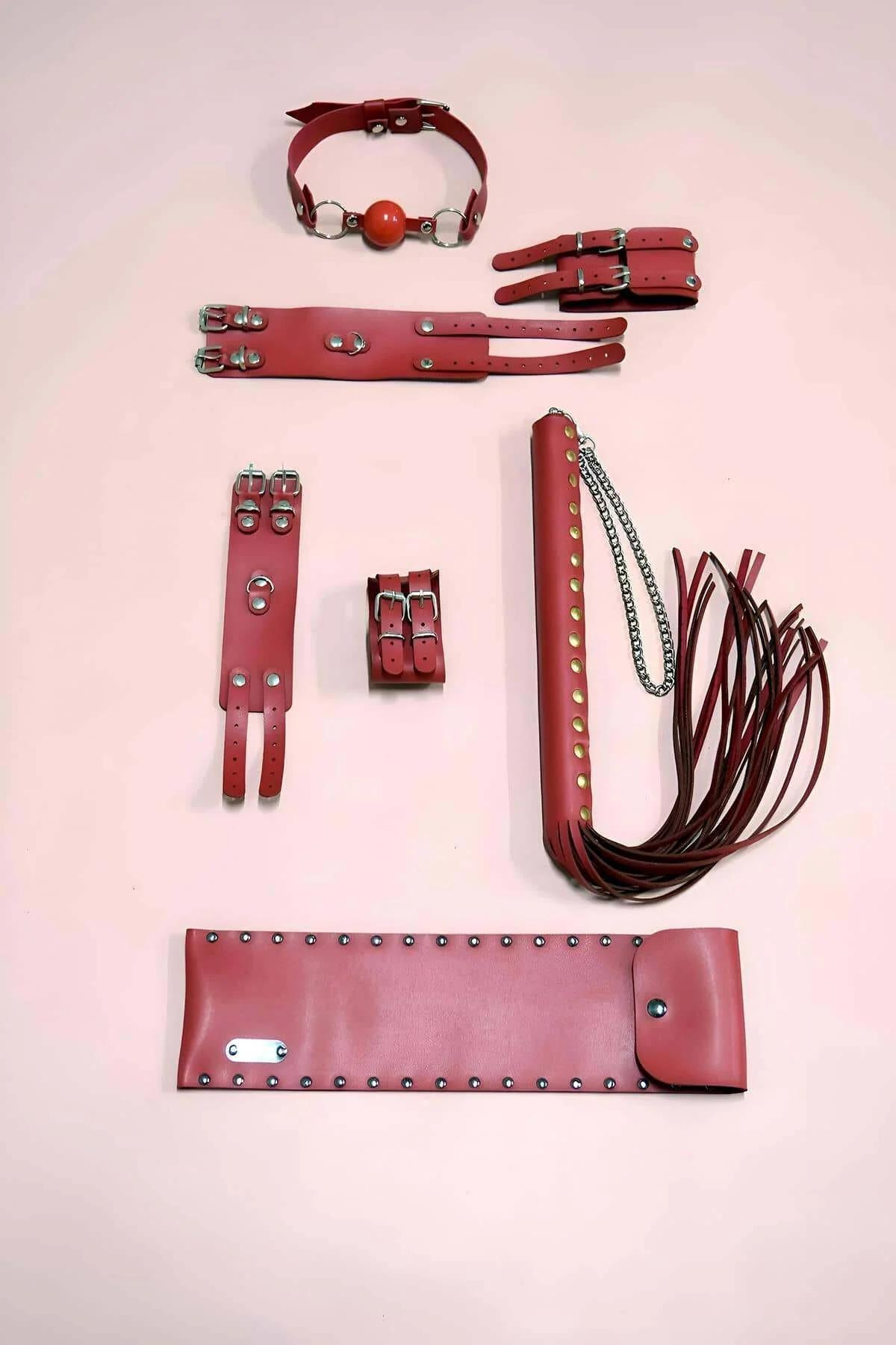 Crimson faux leather double-buckle wrist cuffs with silver D-rings, close-up detail