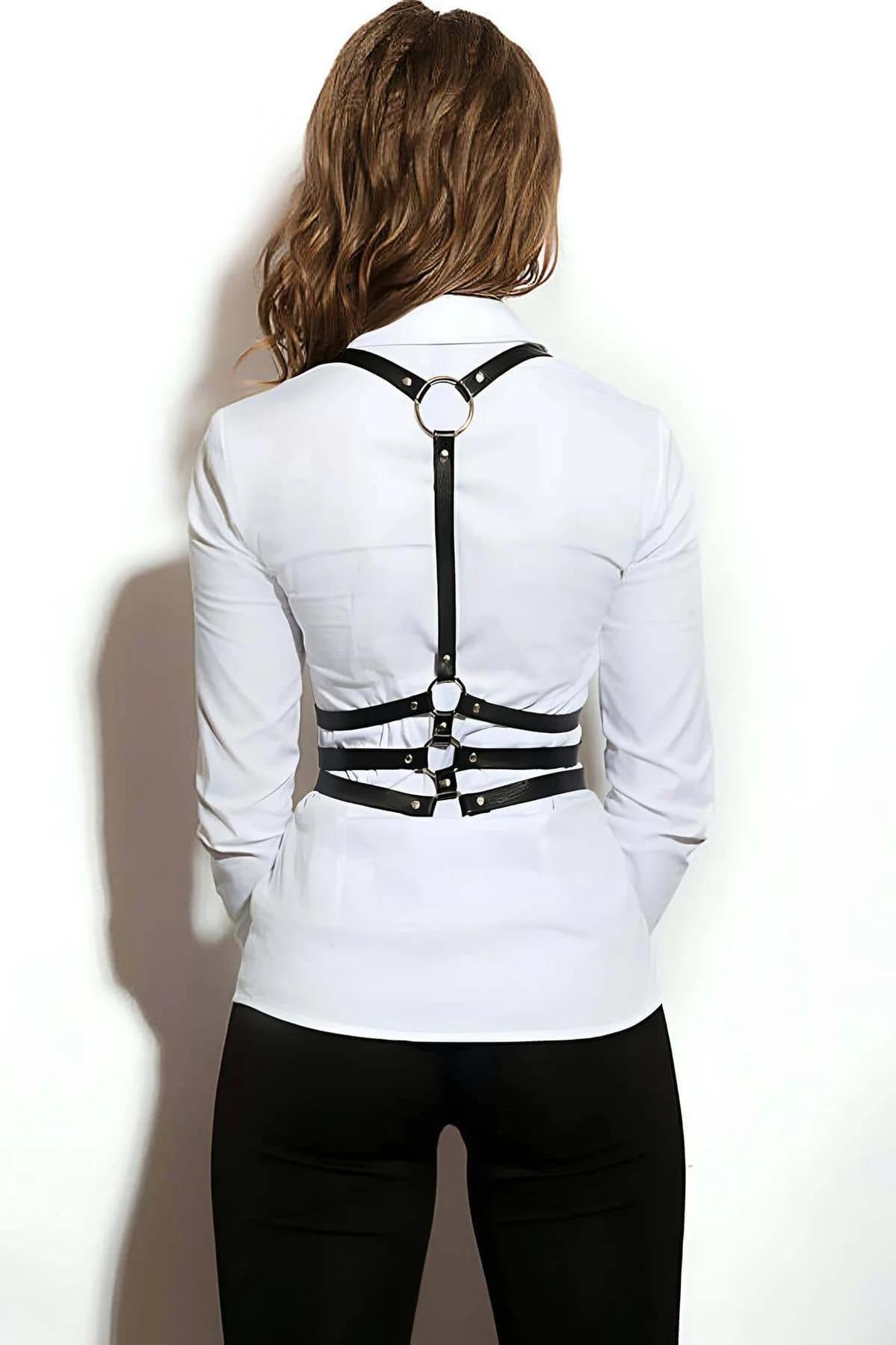 Close-up of three parallel black faux leather straps with gold-tone rectangular buckles on chest harness