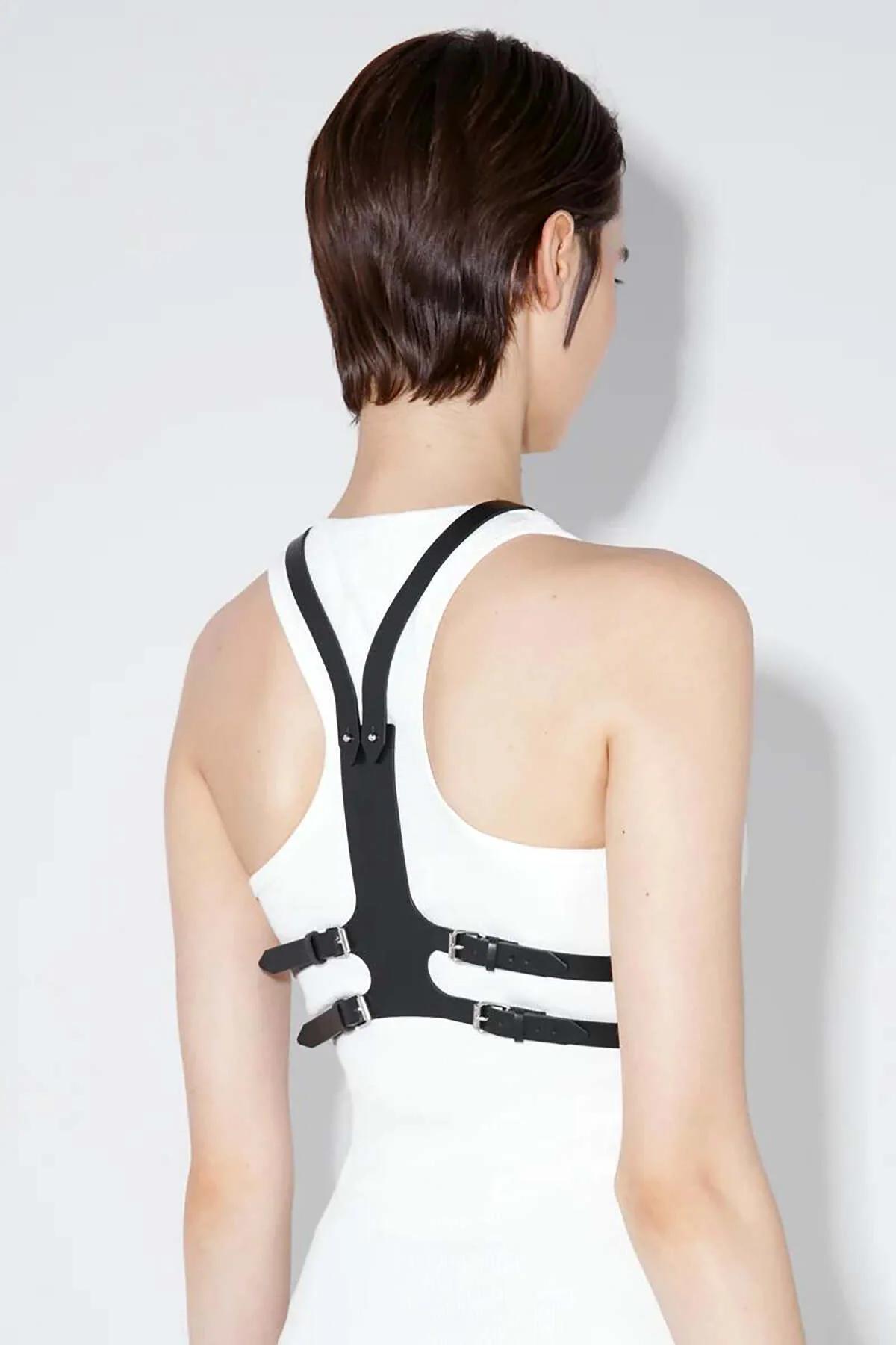 Back view of adjustable metal buckle closure on black faux leather chest harness