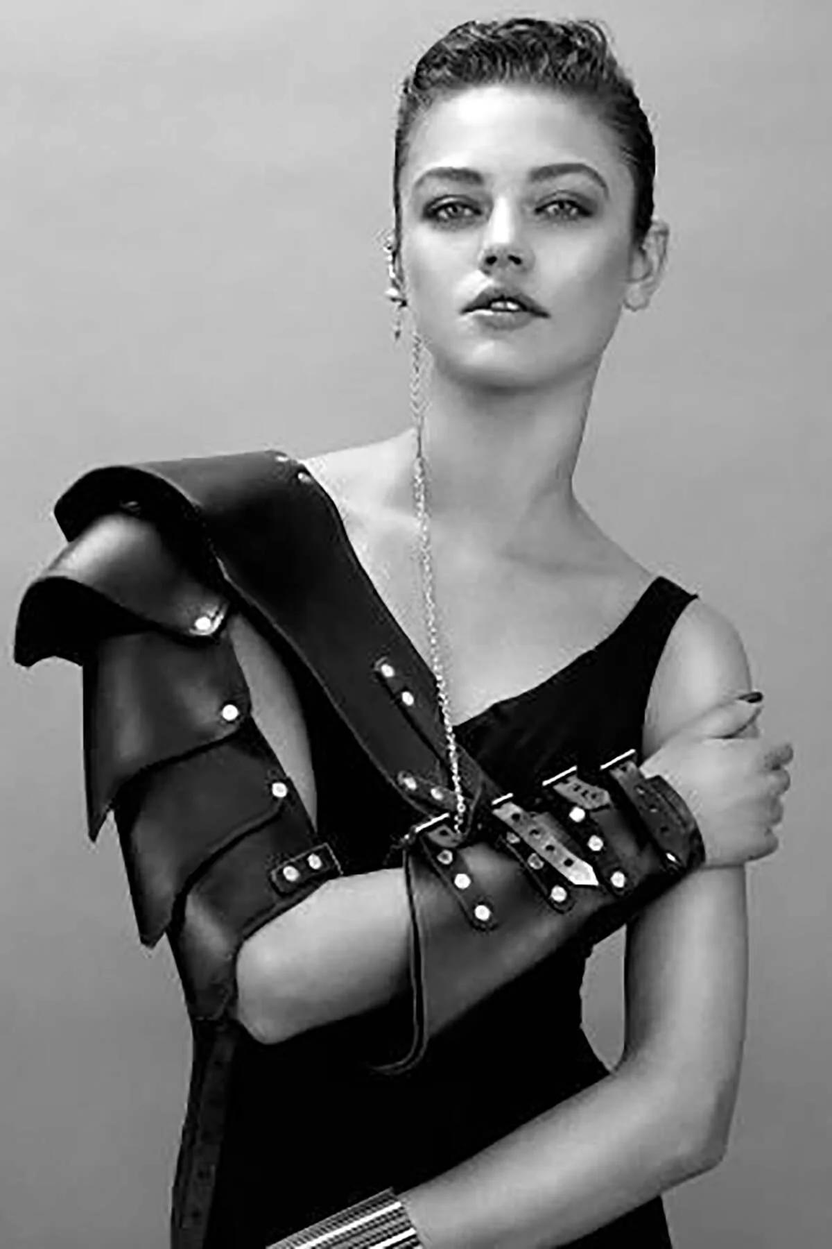 Rear view of black vegan leather shoulder guard panel showing curved edge and silver stud trim