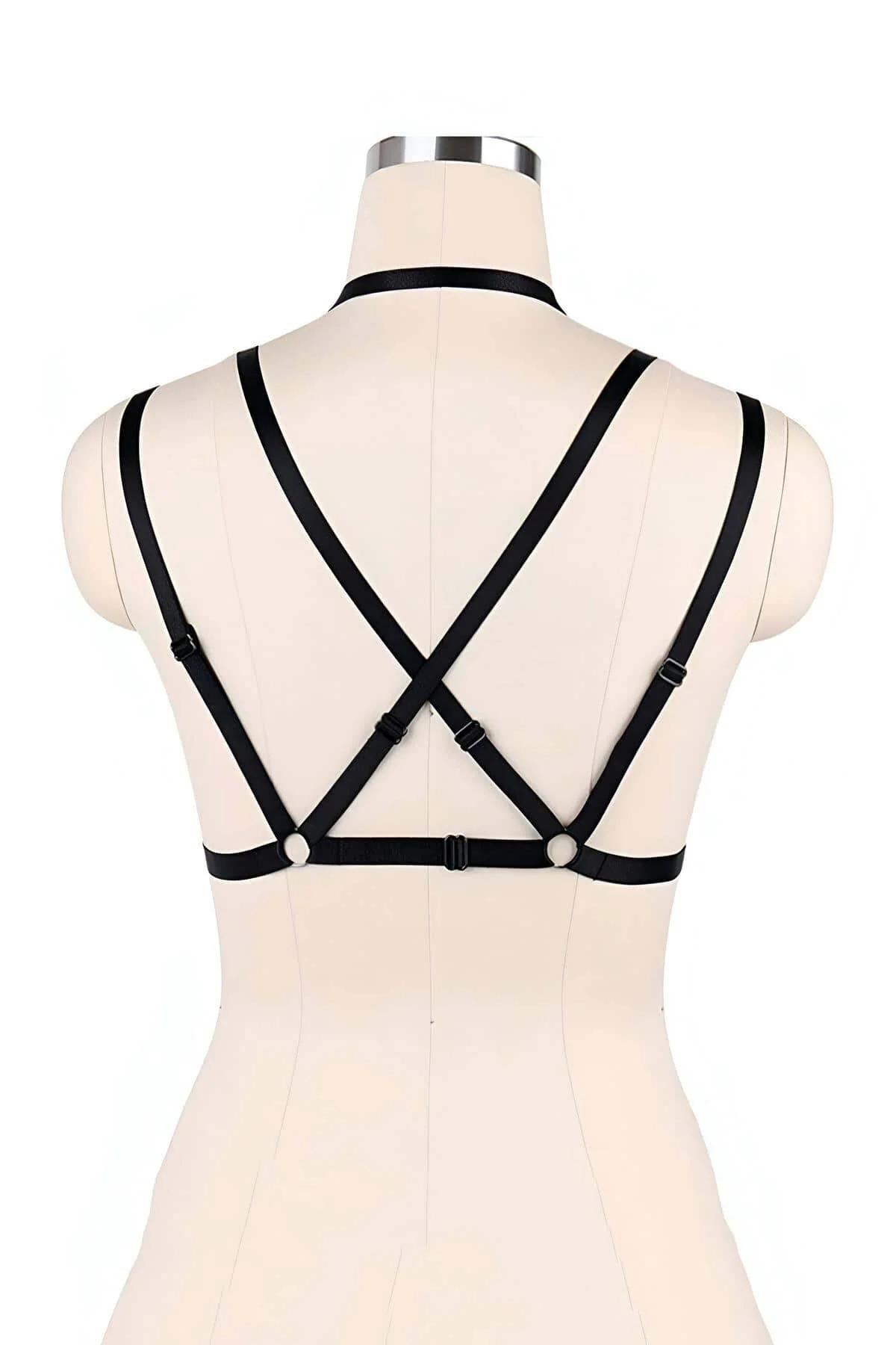 Black chest harness with triple parallel straps worn over bare skin, star and O-ring visible at center