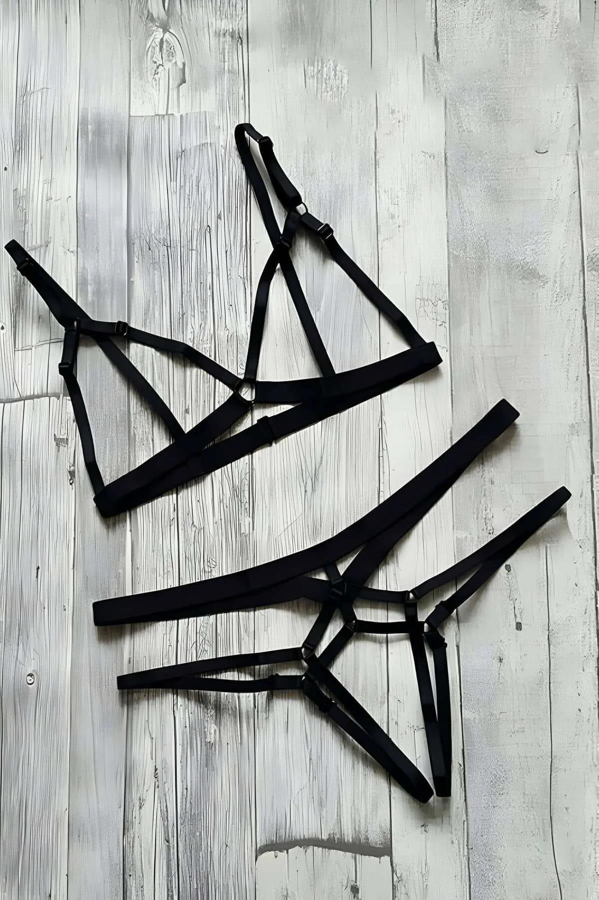 Side view of black strappy harness briefs with beige woven panel and side buckle closure detail