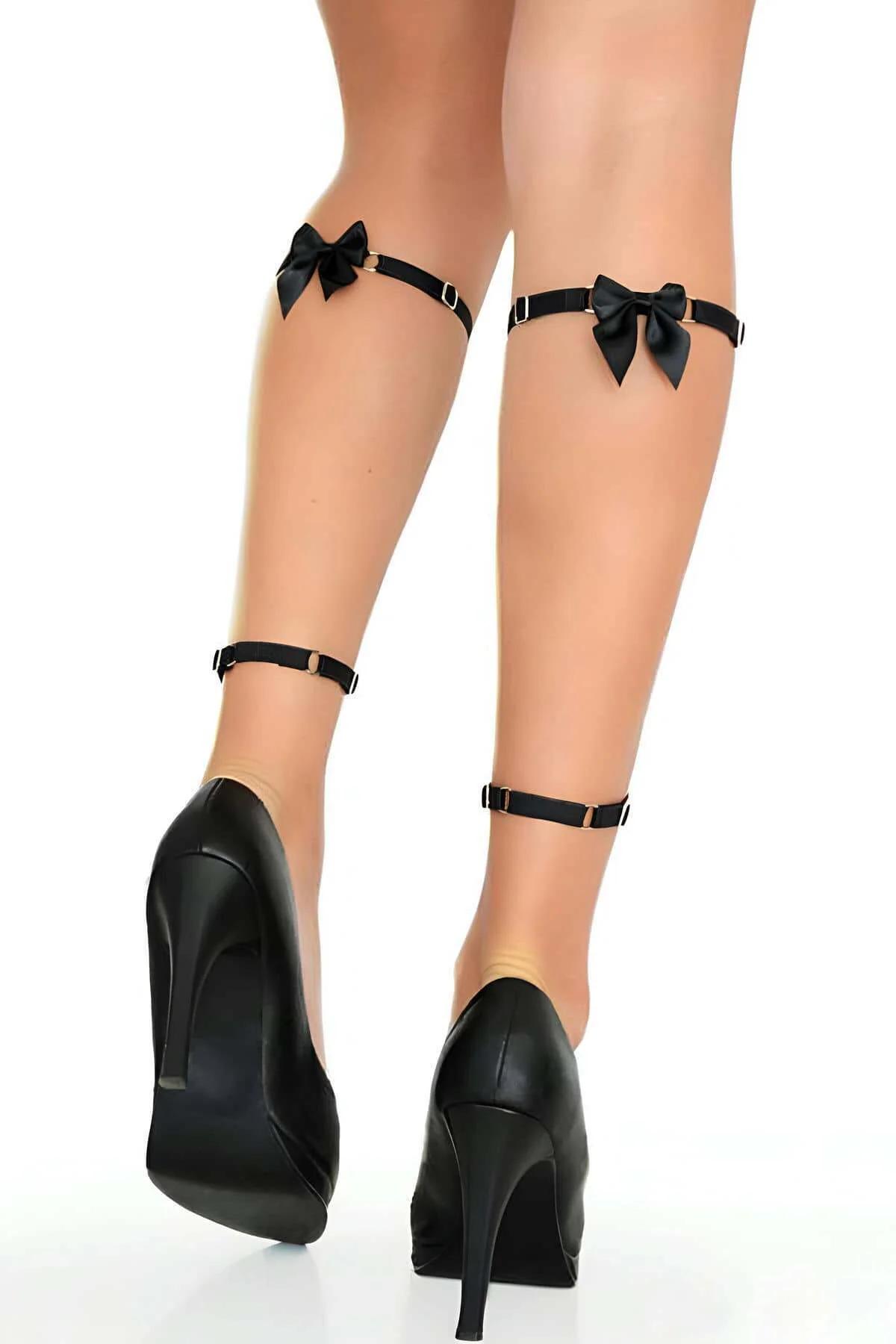 Close-up of silver O-ring strap intersection on black faux leather leg harness at knee level