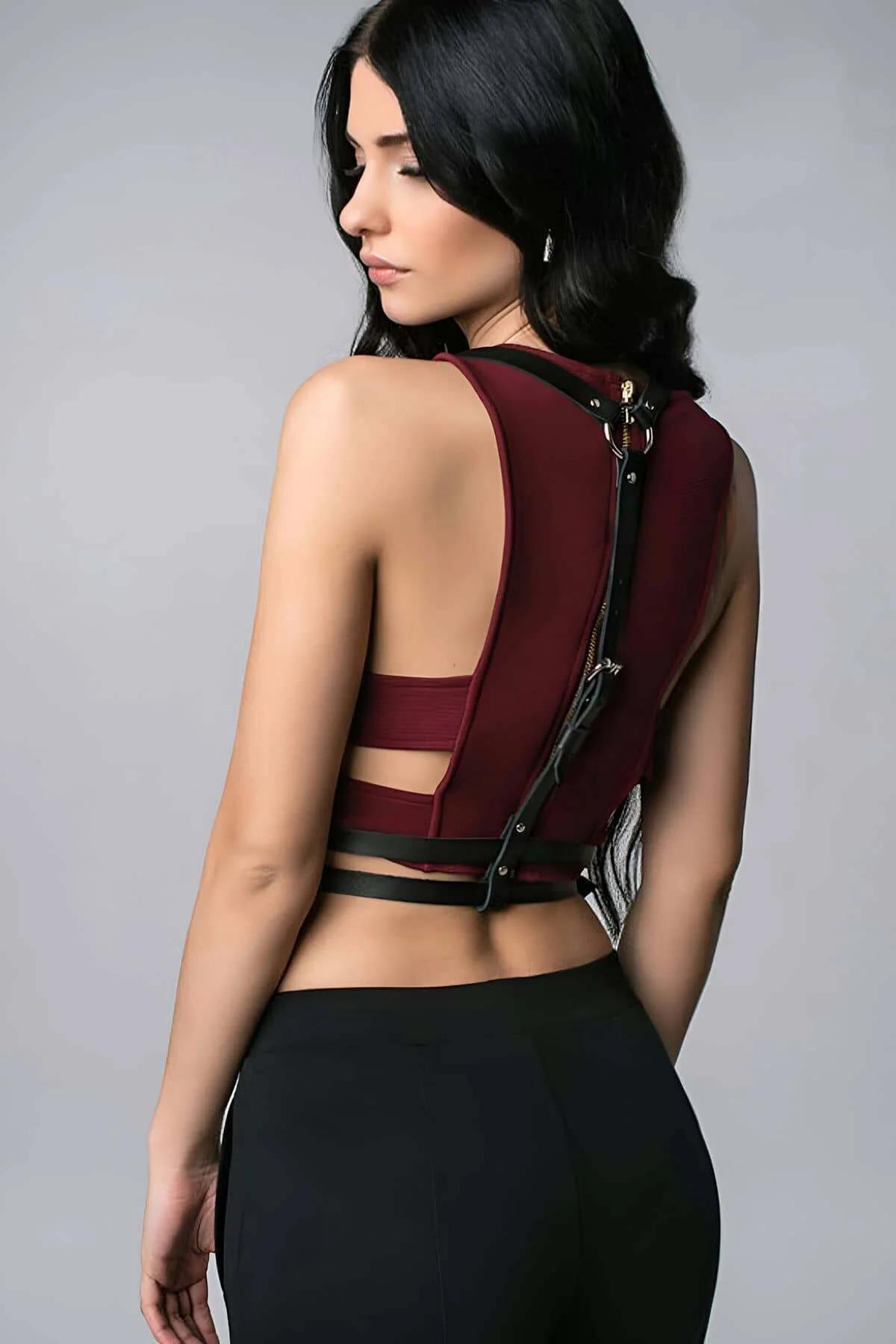 back view of black strappy faux leather harness showing metal buckle shoulder adjusters