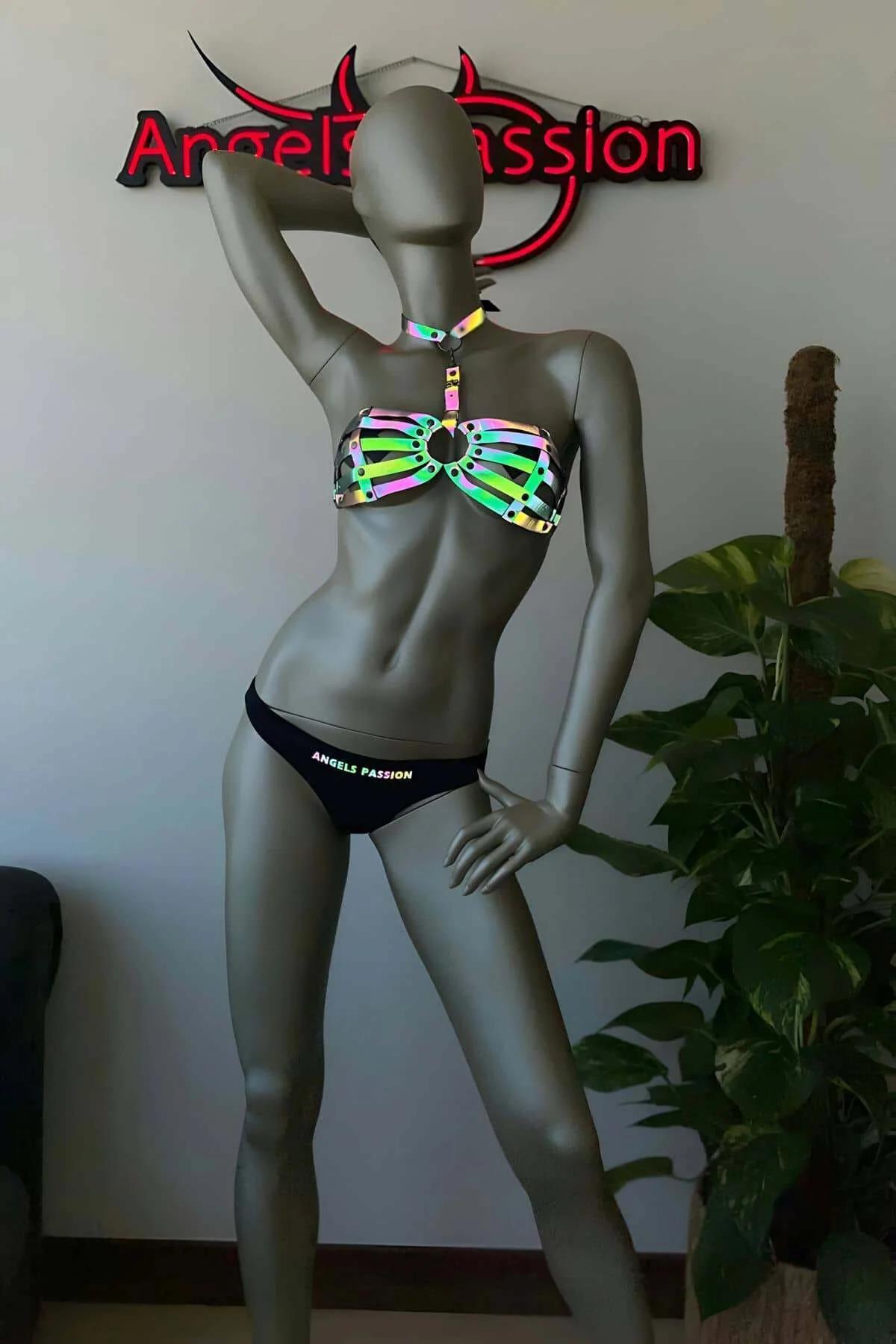 Side angle of iridescent caged harness top worn over dark bodysuit showing adjustable neck strap