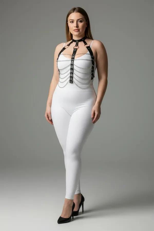 black faux leather chest harness with seven draped silver chains and stud center panel worn over white bodysuit