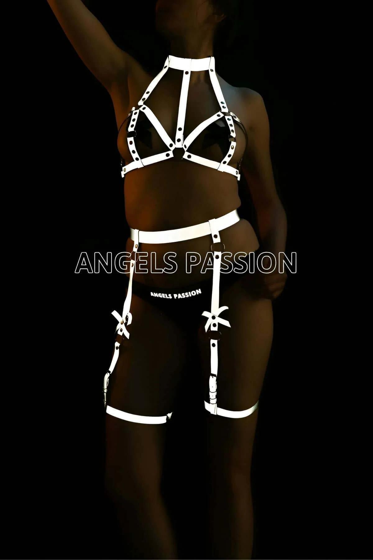 White reflective cage harness and garter set with halter-neck bra top and thigh bands glowing against dark background