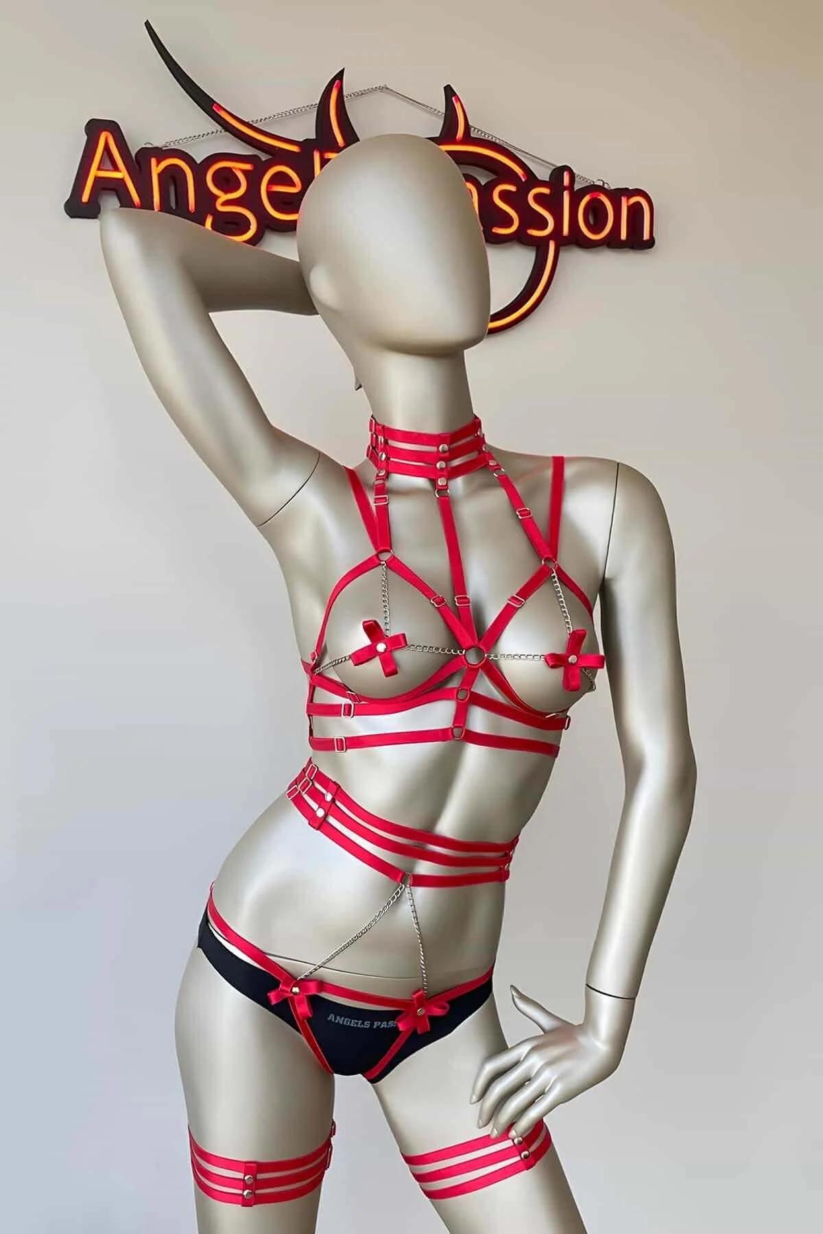 Red full-body harness thigh bands and hip O-ring detail with silver chain connection