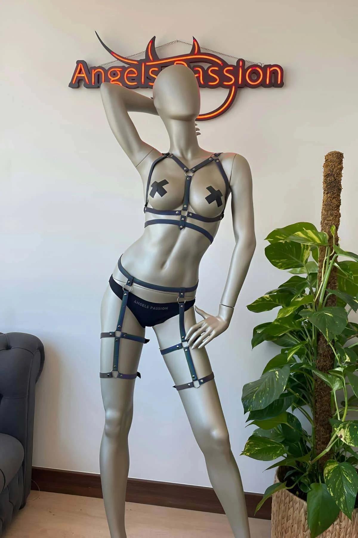 Thigh cage section of rainbow reflective body harness with silver O-ring hardware under stage lighting