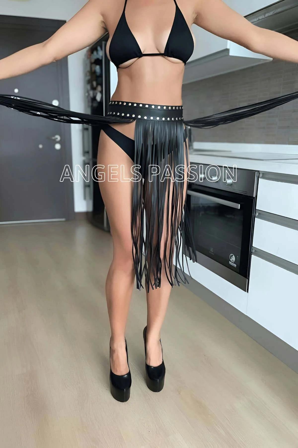 Close-up of silver dome studs on black PU leather waistband of fringe belt