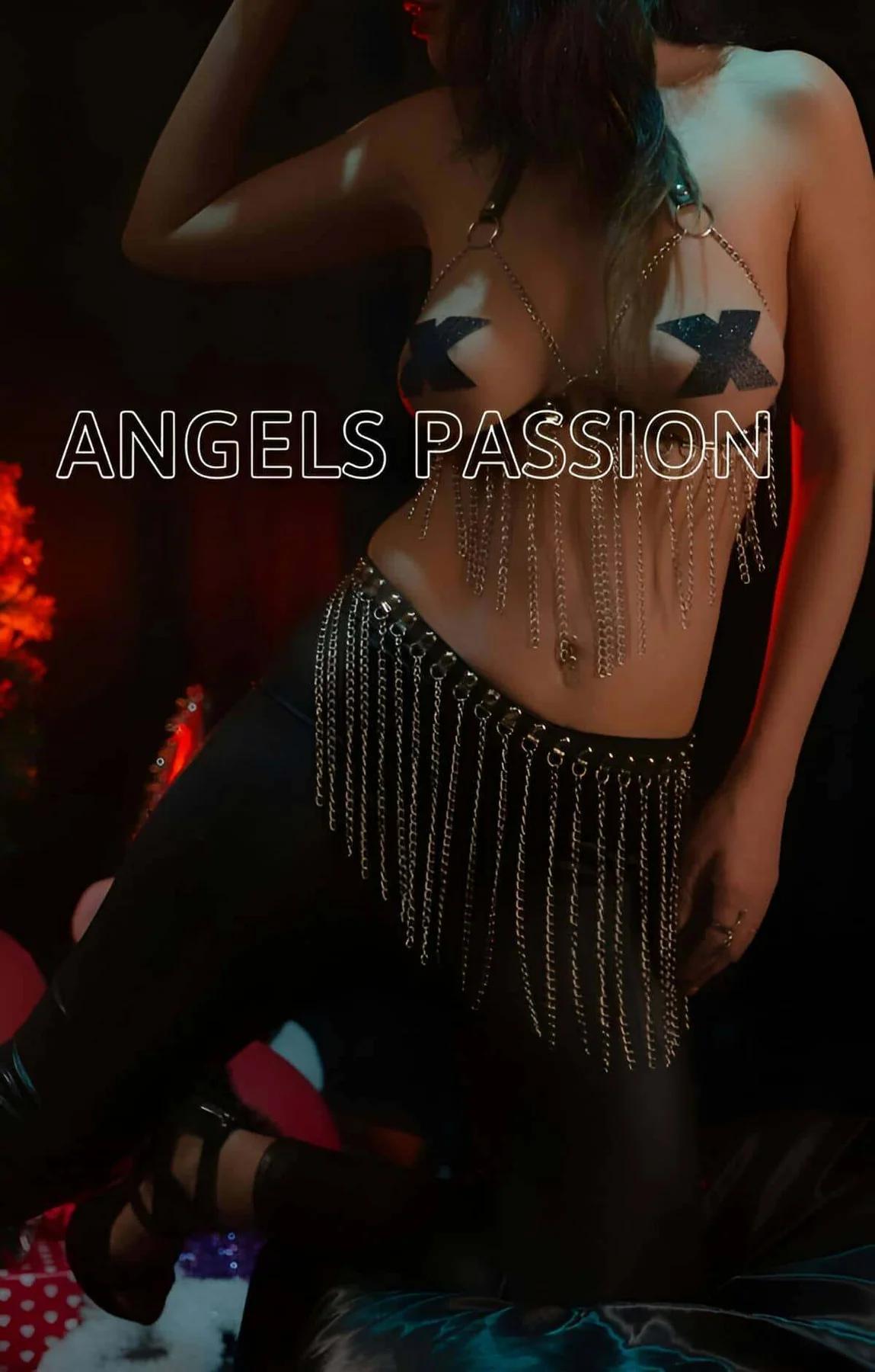 Close-up of silver O-ring, adjustable straps, and chain fringe detail on black leather harness bra
