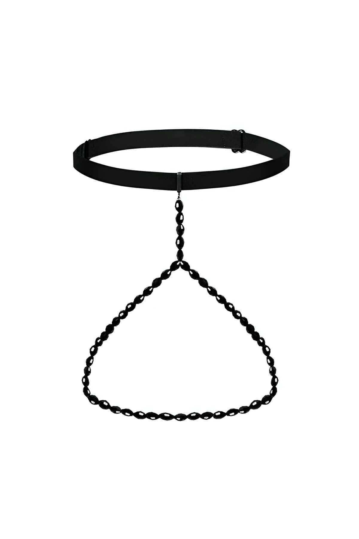 Close-up of gold-tone chain links connecting black elastic strap bands on thigh garter harness
