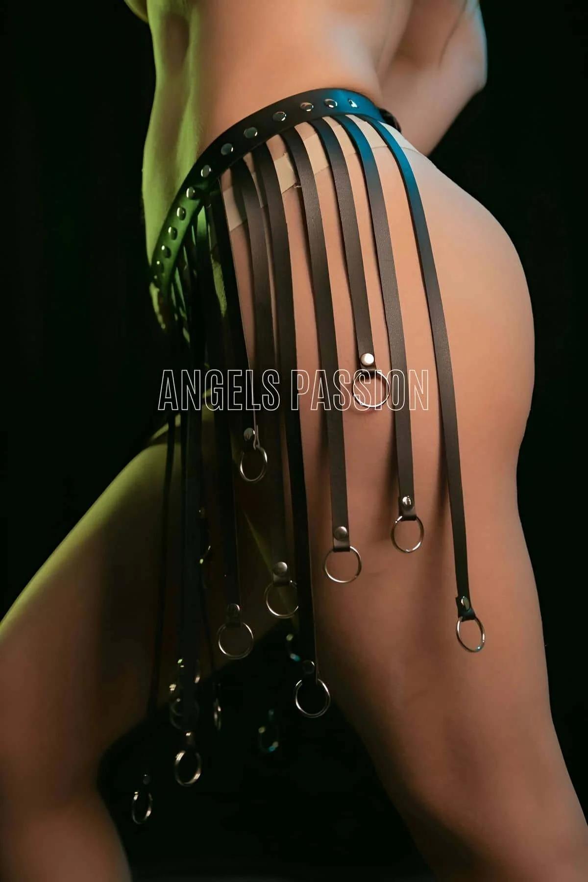 Close-up of black faux leather fringe straps with silver O-ring hardware at hem