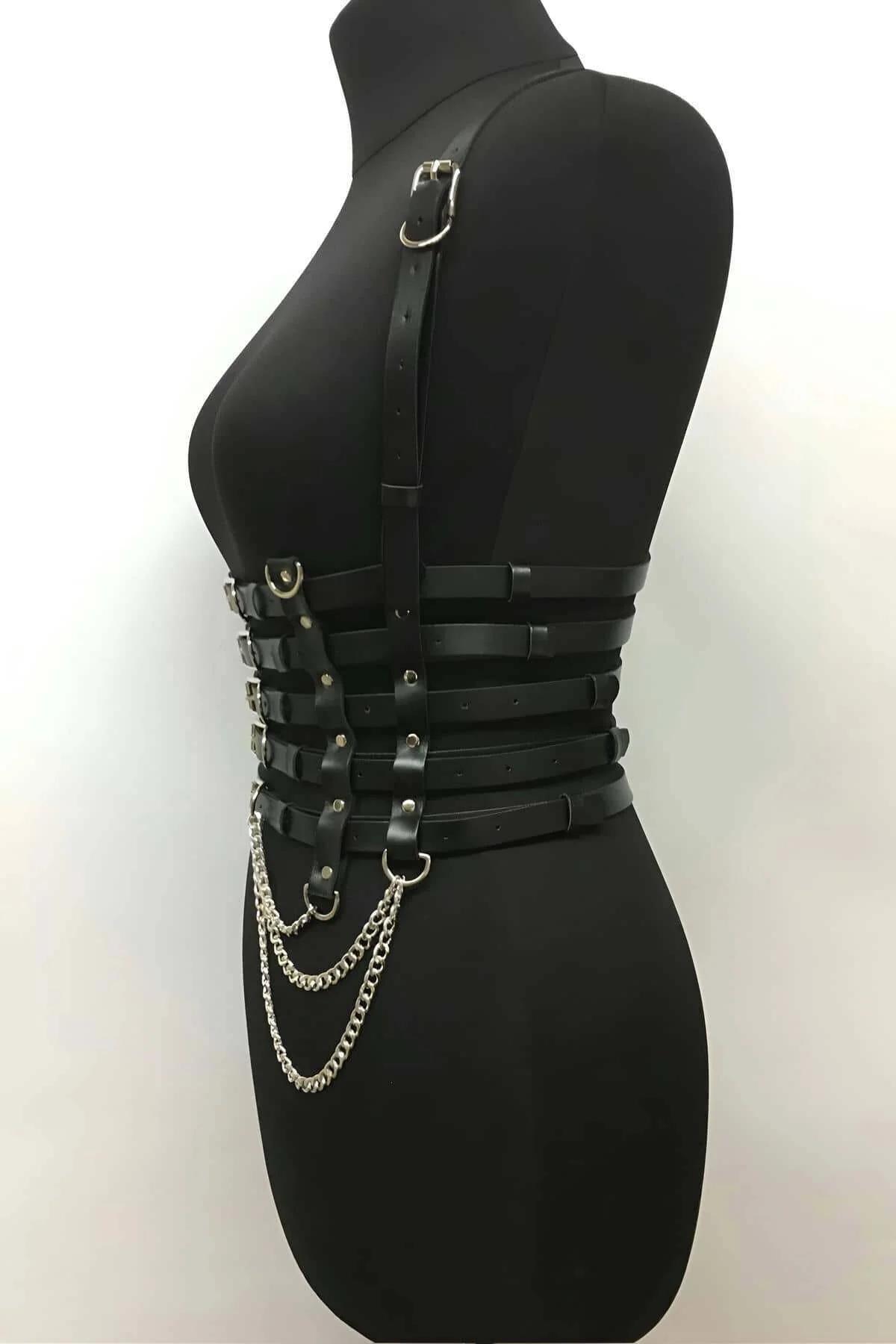 Close-up of five silver rectangular buckles on black faux leather corset harness waist straps