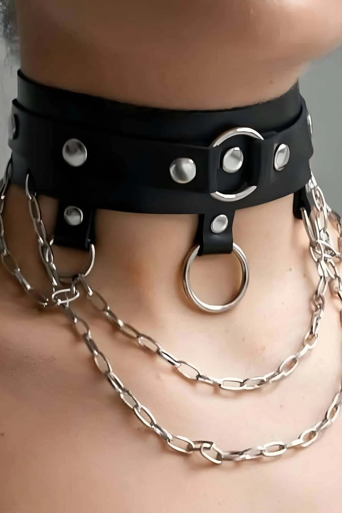 Close-up of black PU leather choker band showing silver dome rivets and front O-ring detail
