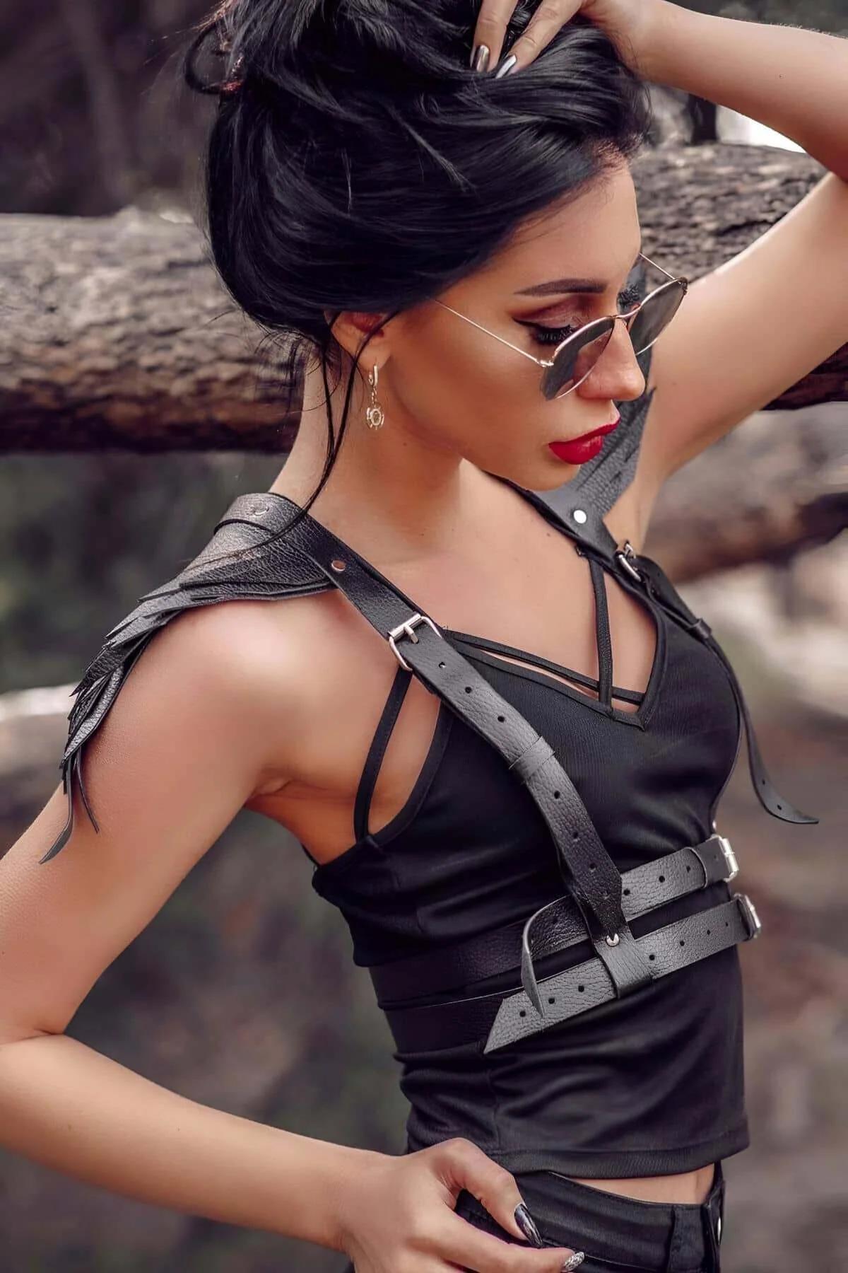 Close-up of double silver rectangular buckles on wide black faux leather waist belt harness