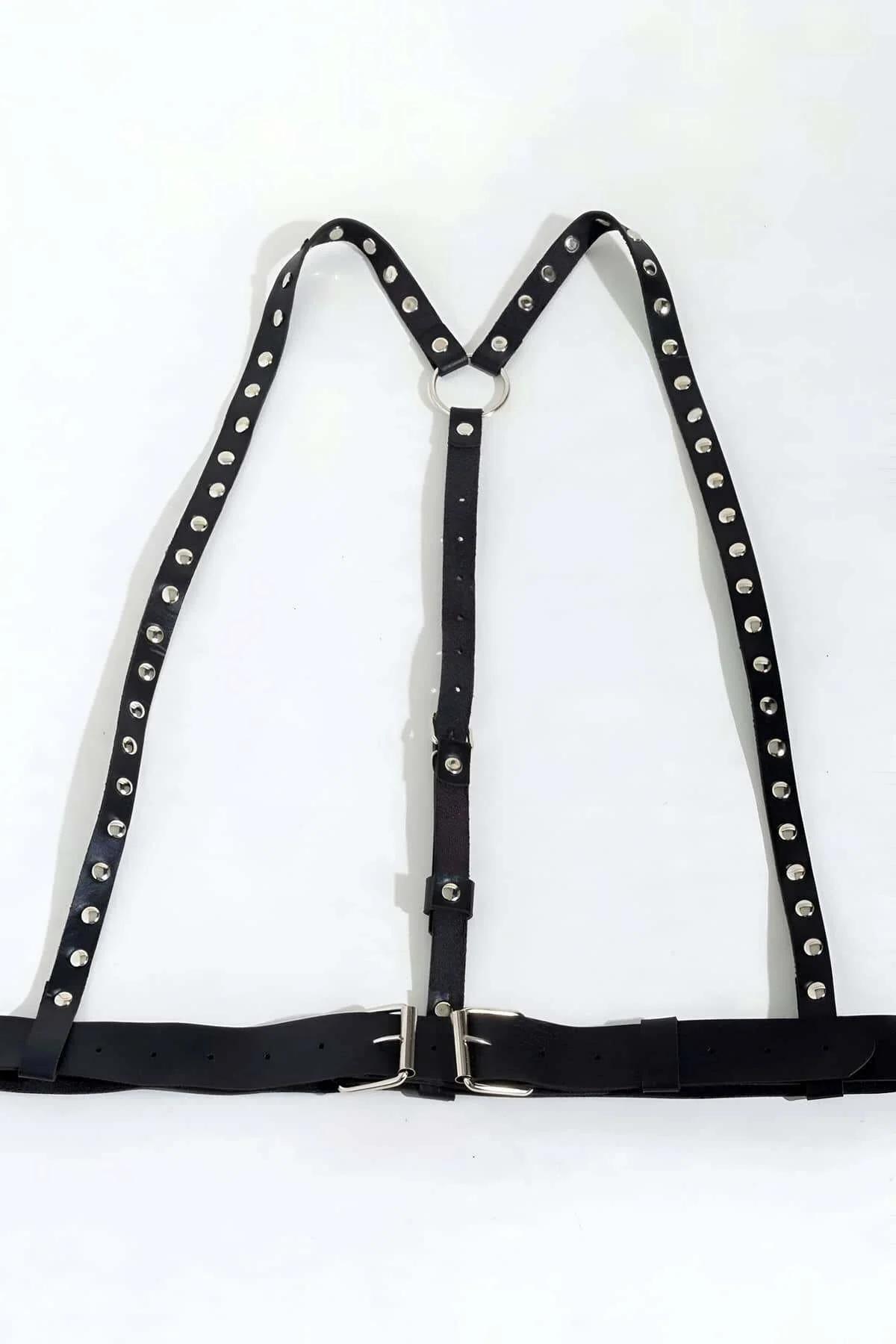 Close-up of silver dome studs riveted along black faux leather shoulder strap of harness
