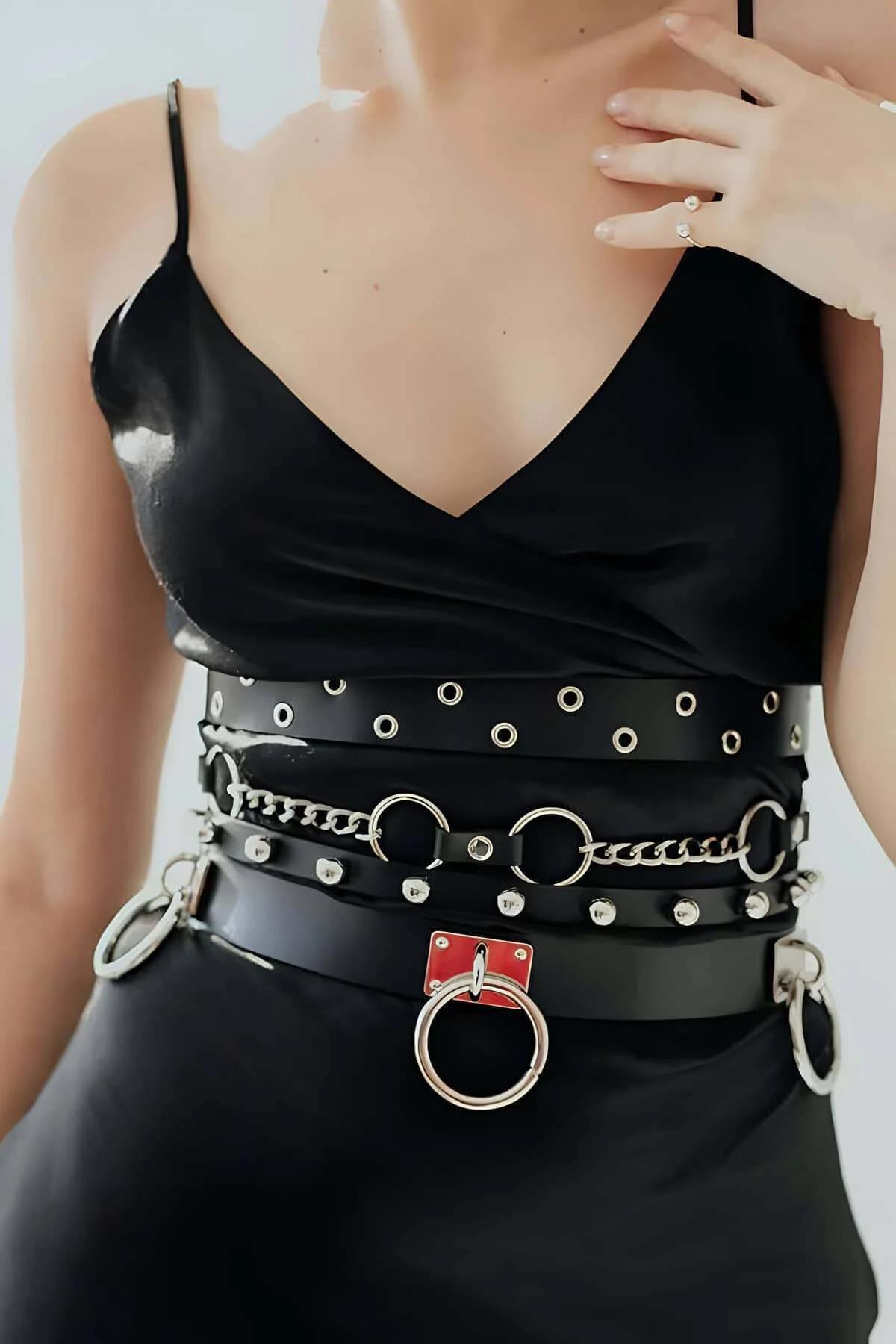 close-up of silver chain and O-ring hardware on black faux leather belt center band