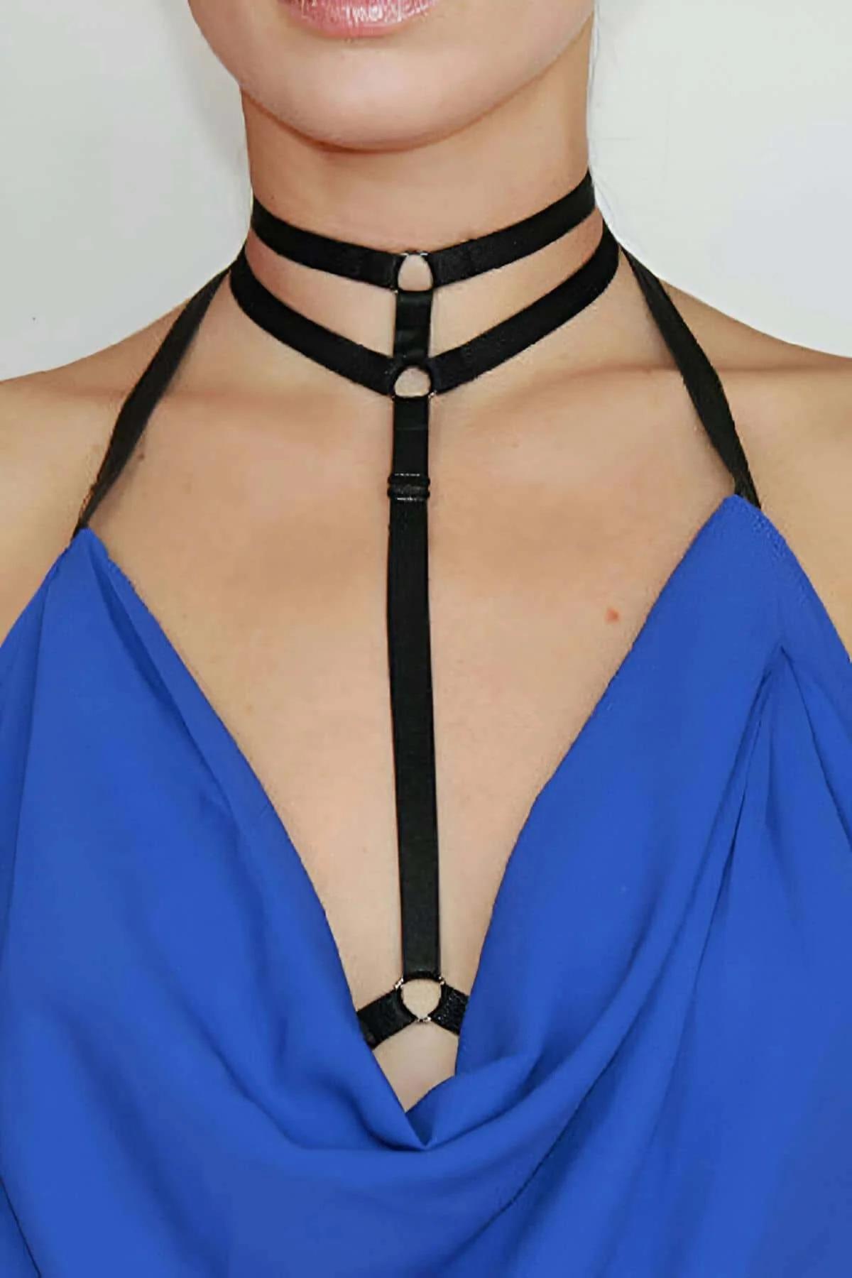 Close-up of double parallel black elastic choker bands with gold O-ring connector at neck junction