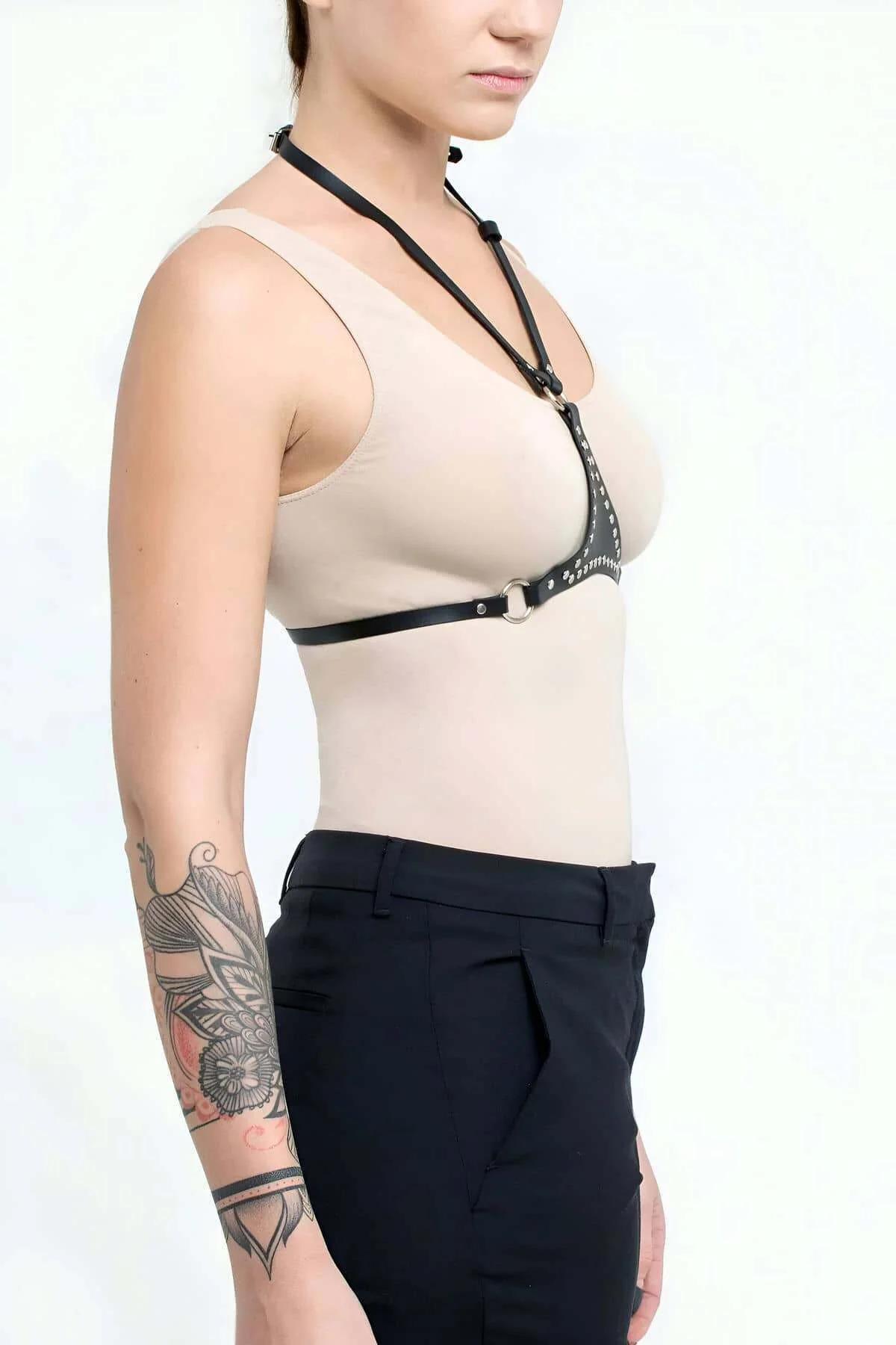close-up of silver-tone pressed metal studs on black PU leather harness front bands