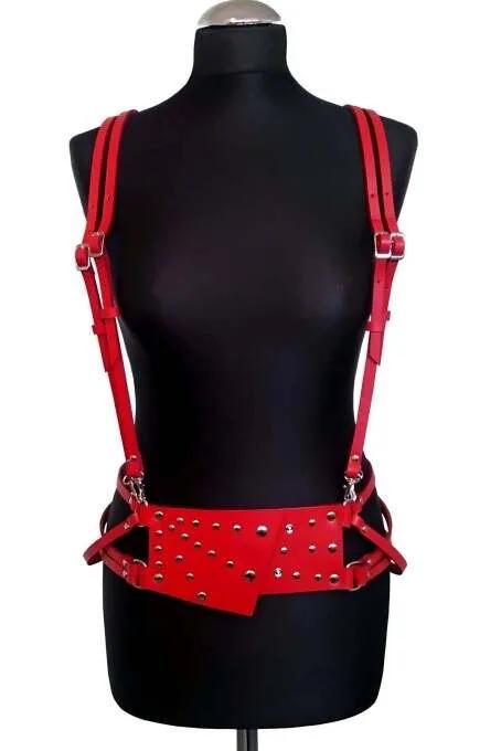 Red faux leather body harness with silver dome studs on wide waist panel and adjustable shoulder straps on mannequin