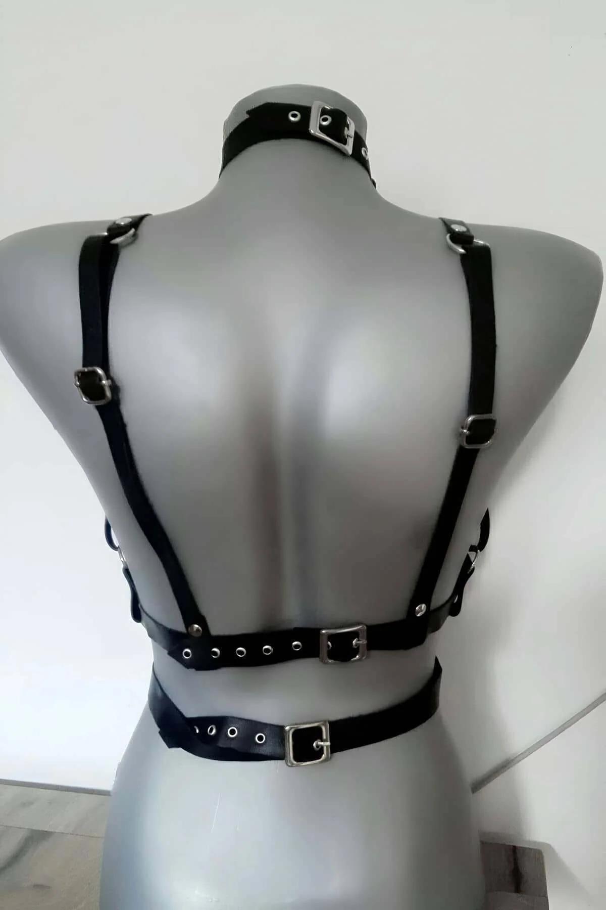 Black matte faux leather chest harness laid flat showing four adjustable pin-buckle straps