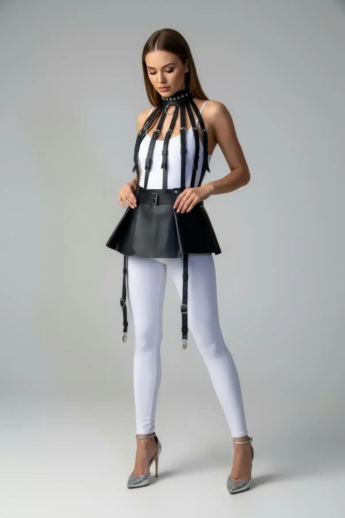 Black faux leather peplum harness skirt showing flared silhouette and buckle waistband detail