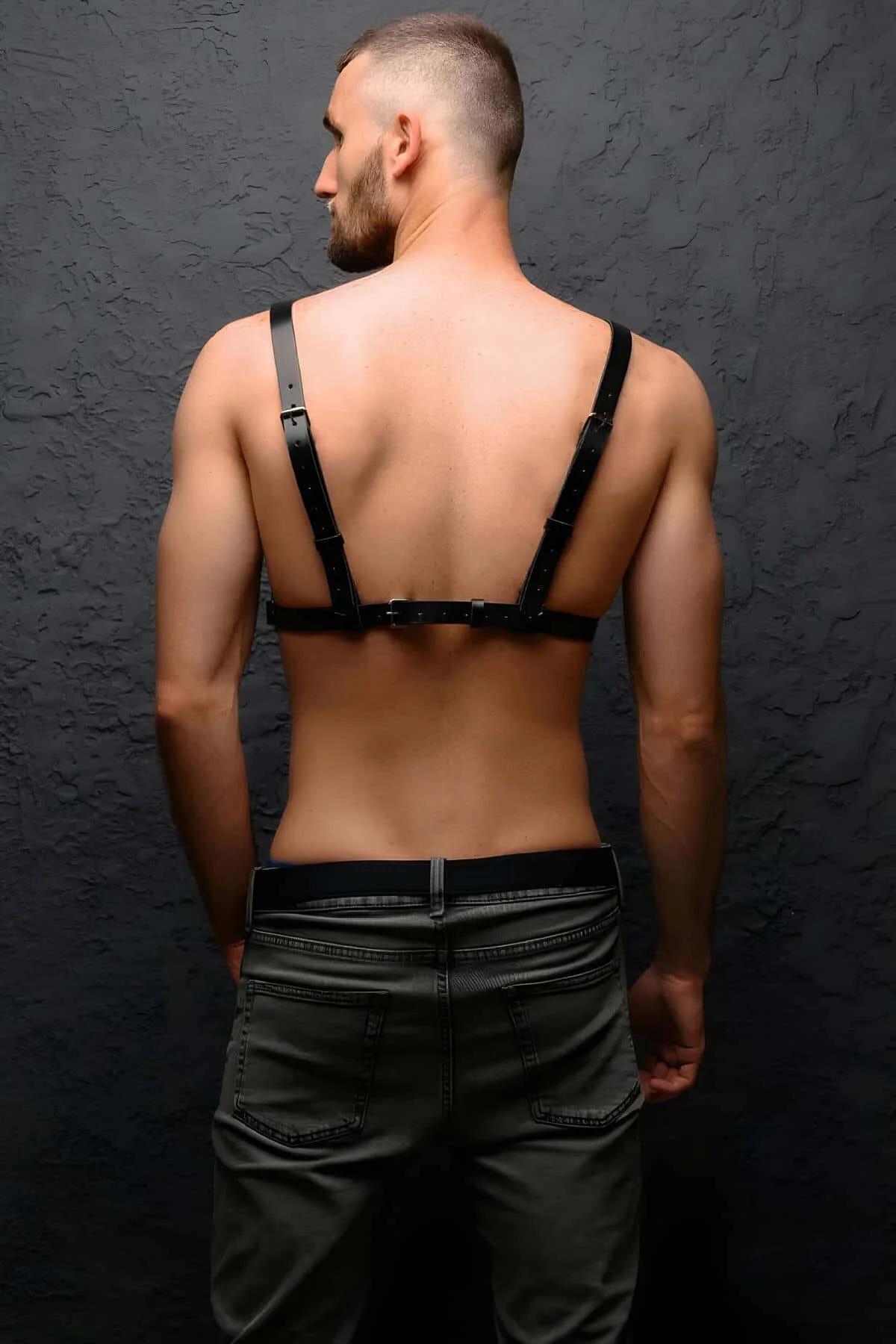 close-up of silver O-ring at sternum on black faux leather chest harness