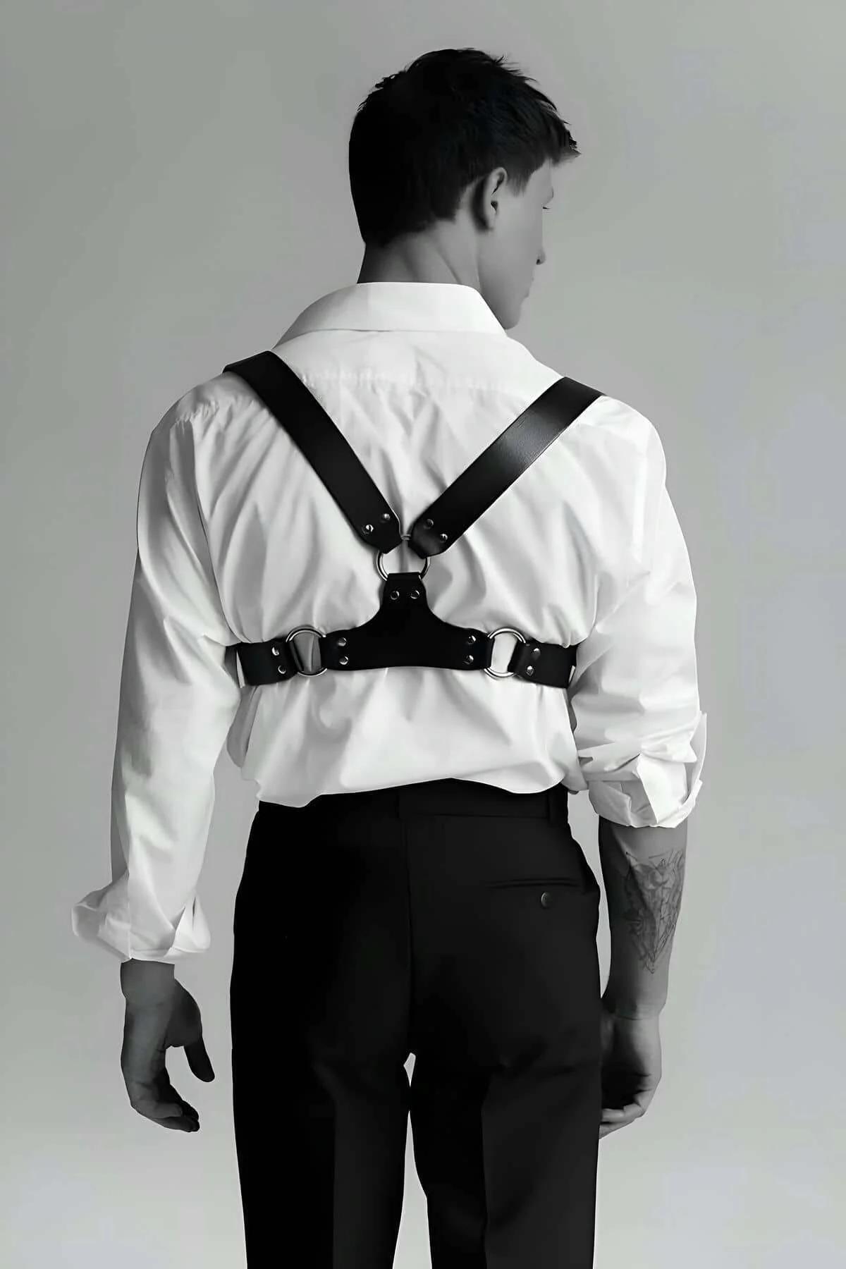 Front view of black PU leather chest harness vest showing twin silver buckles at sternum