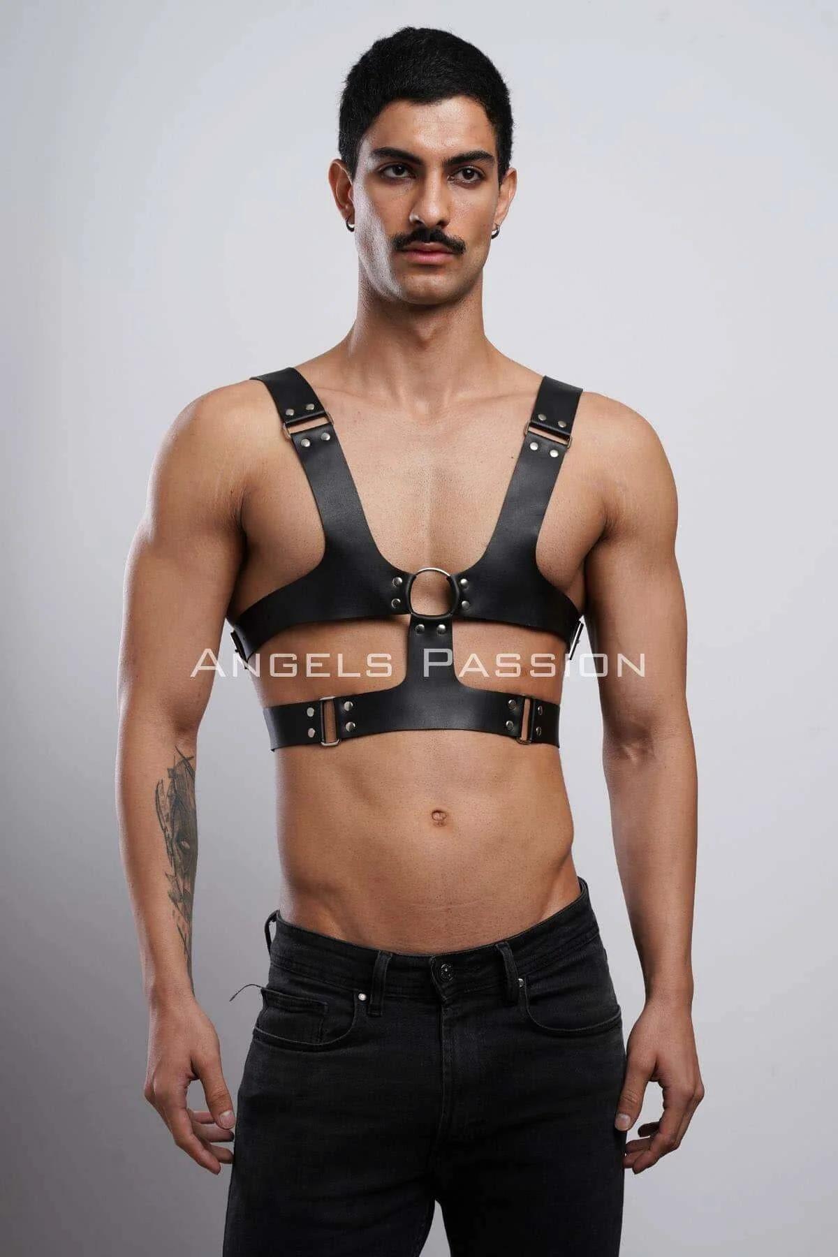 Close-up of bronze O-ring detail and rivet-reinforced strap junctions on black faux leather harness