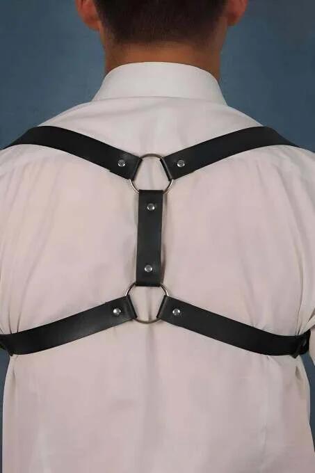 close-up of silver O-ring junction on black faux leather back harness straps