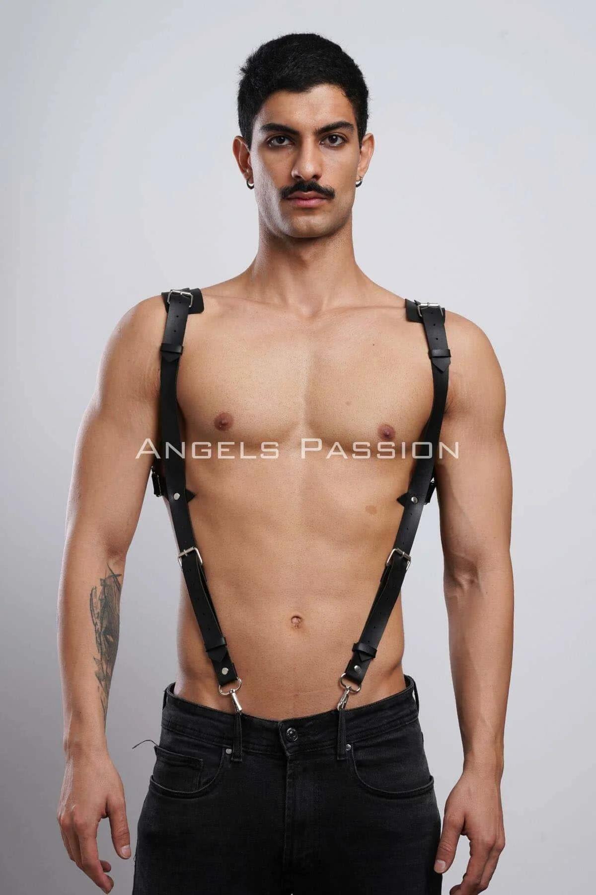 Full torso view of adjustable black faux leather chest harness with silver hardware over dark jeans