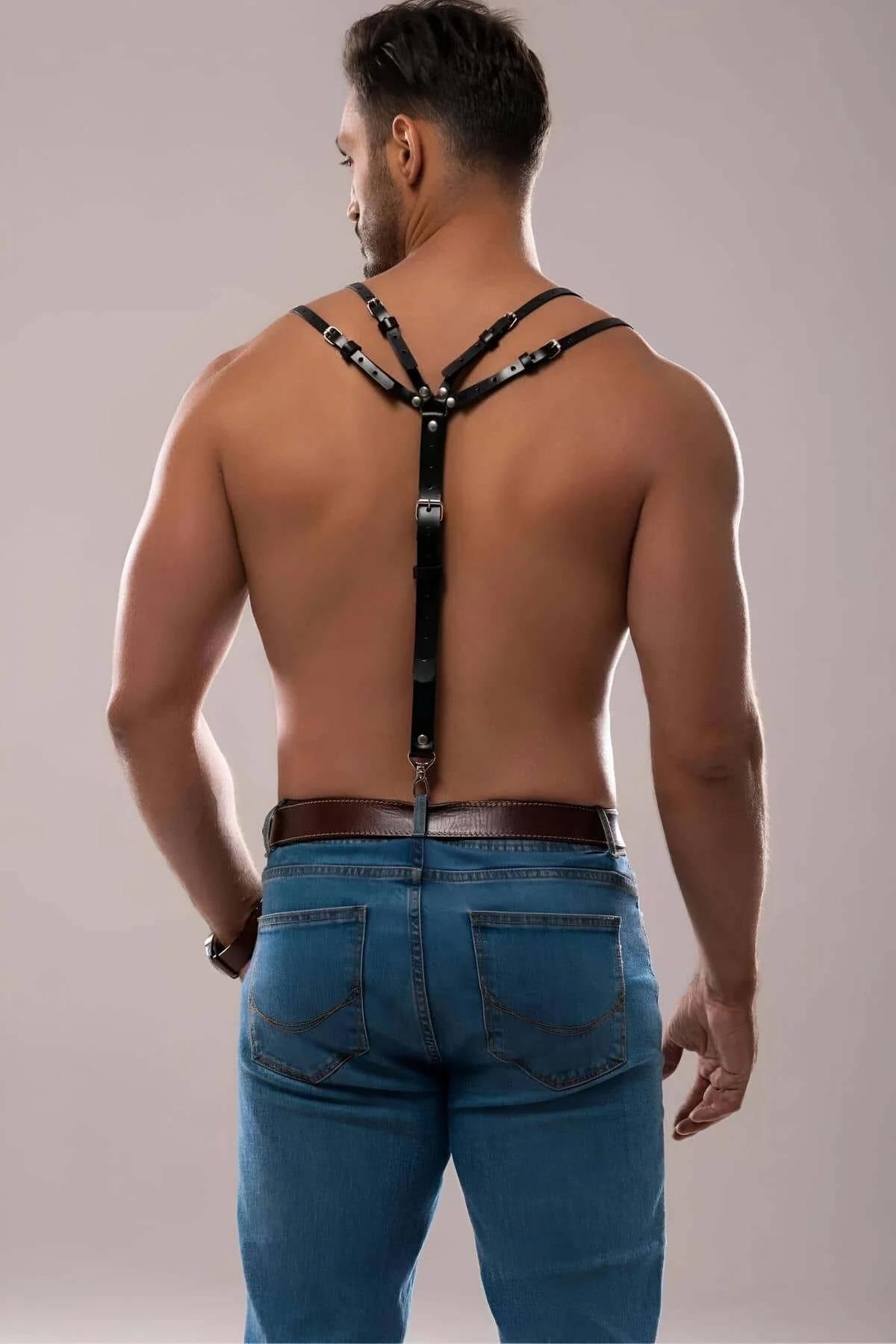 black faux leather shoulder harness layered over white fitted shirt for street styling