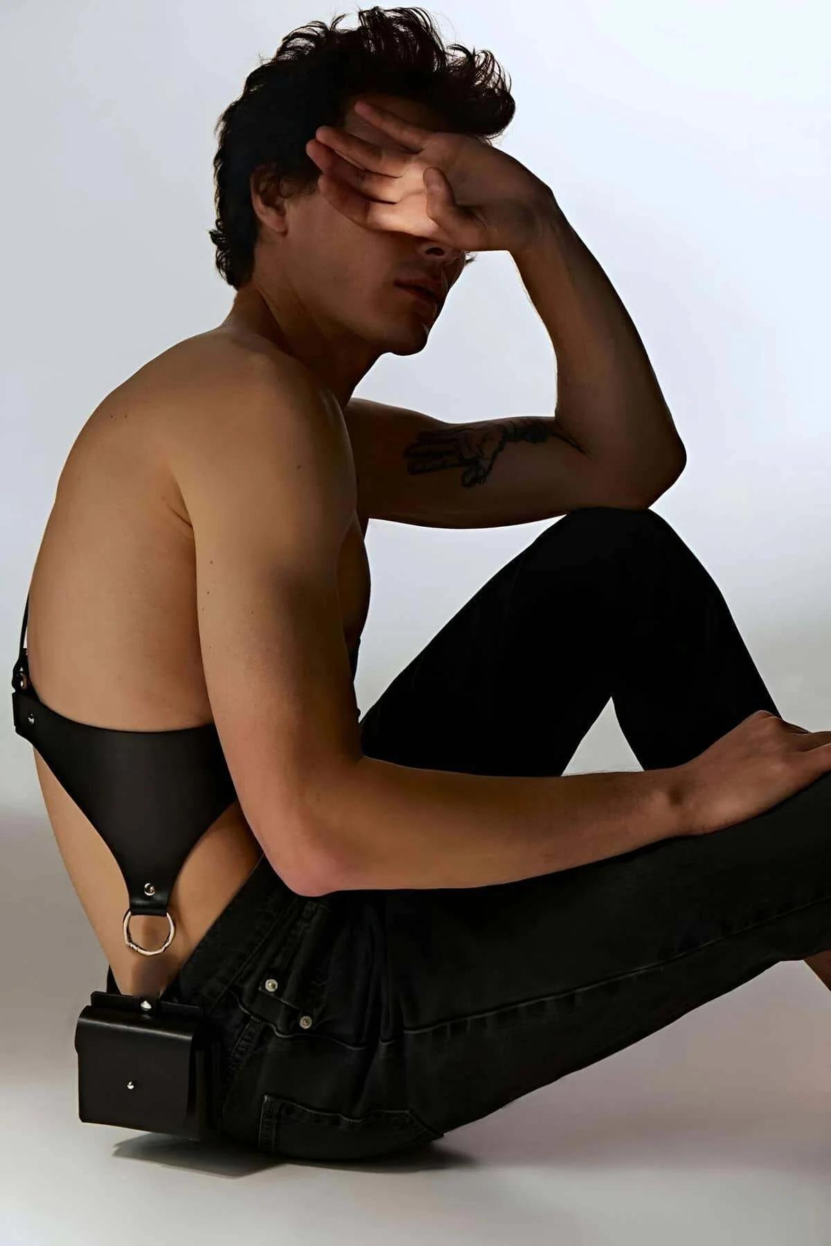 black body harness with gold hardware layered with dark trousers street style men