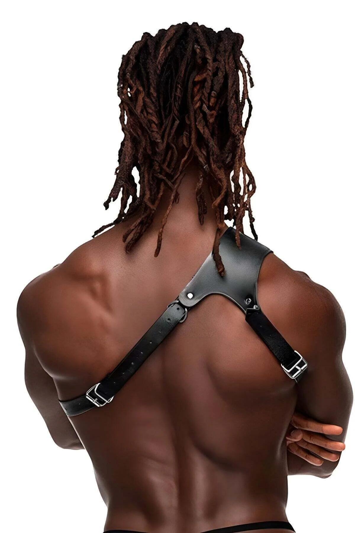 Close-up of brass O-ring junction on black faux leather single shoulder harness