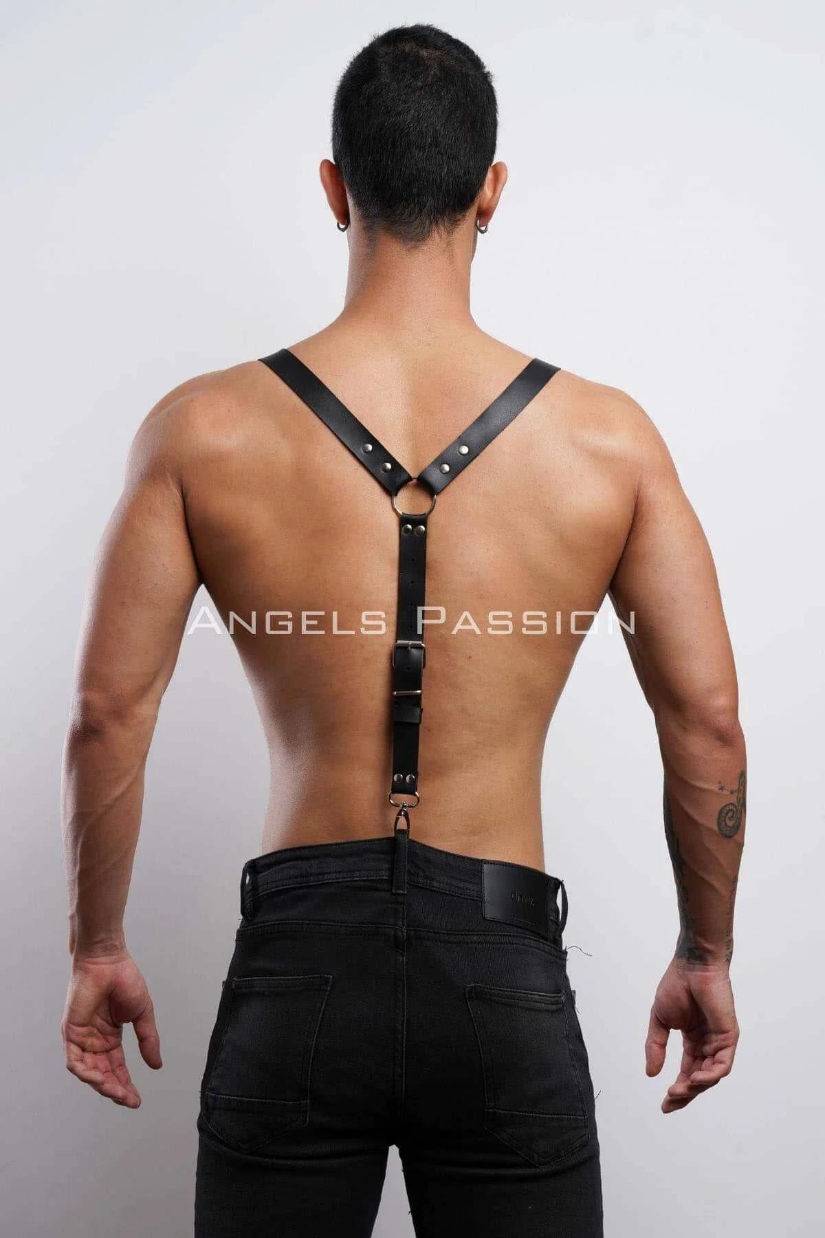 Clip-on strap ends of black faux leather shoulder harness hooked to waistband of dark trousers