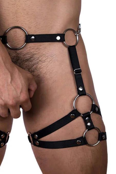 Black faux leather men's body harness with five silver O-rings and removable chain link, worn on hip and thigh