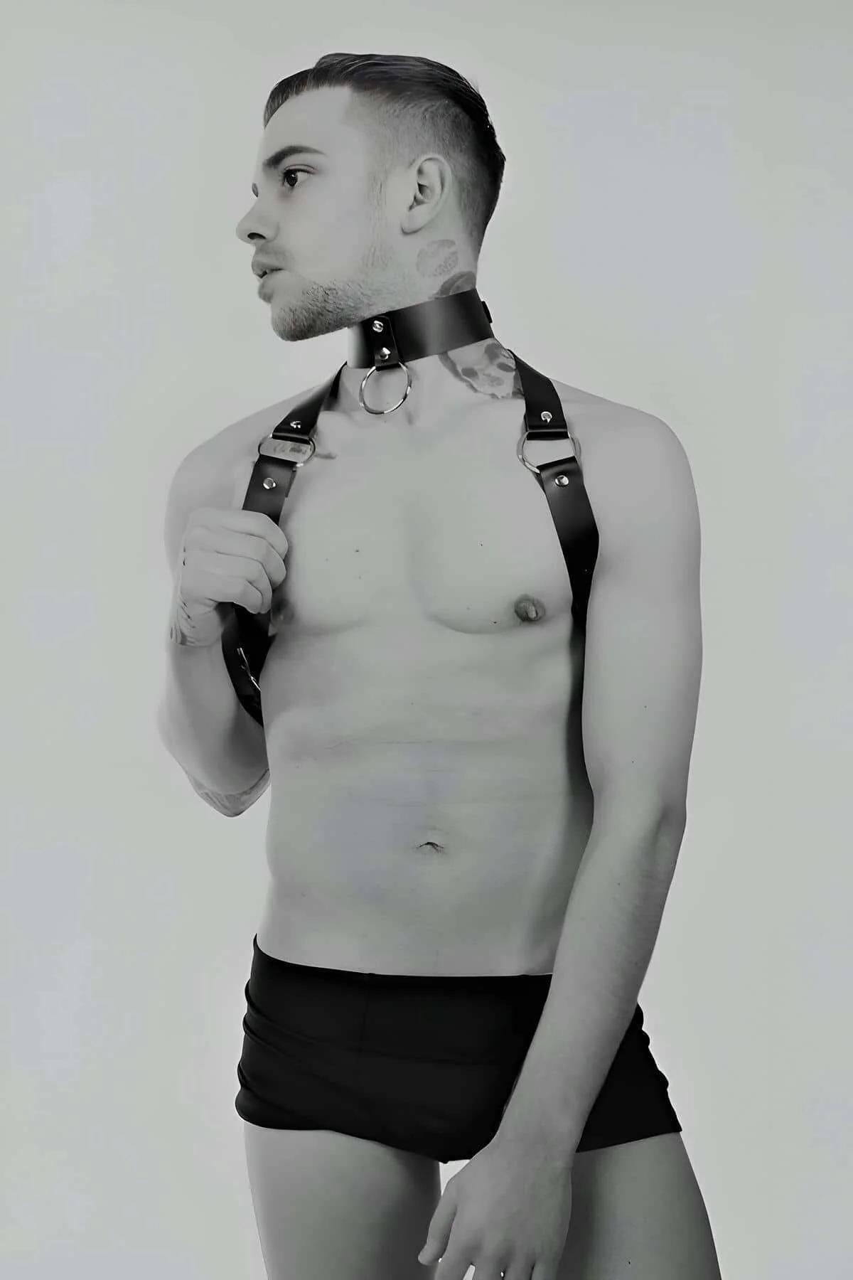 Close-up of silver O-ring and snap-stud collar on black faux leather chest harness