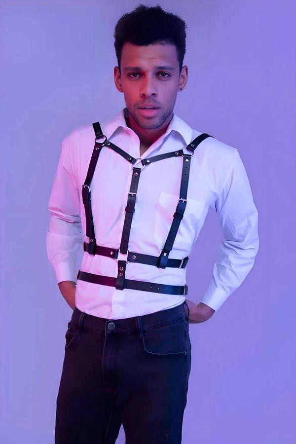 Black faux leather adjustable chest harness with silver O-rings and buckles worn over white shirt
