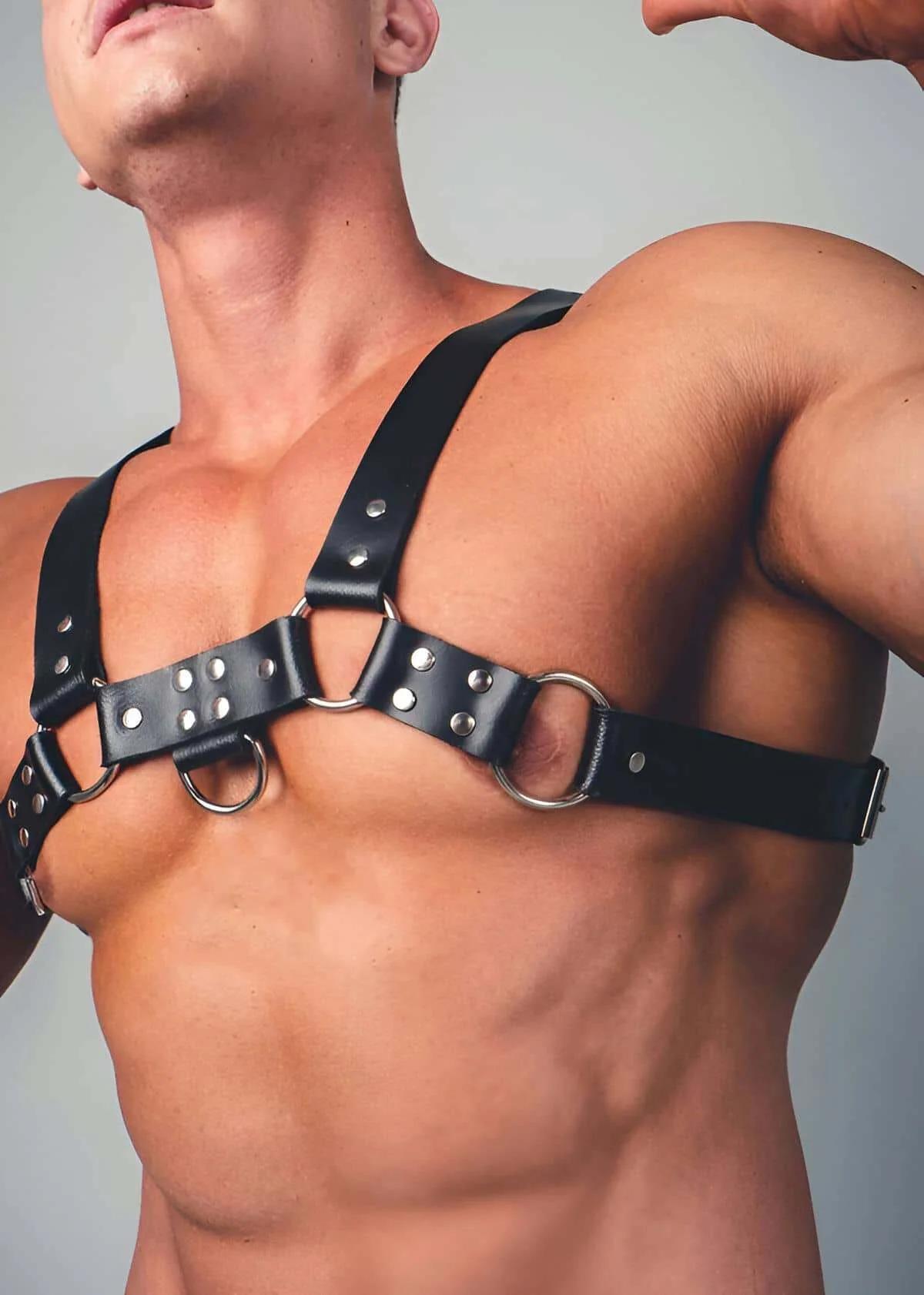 black vegan leather chest harness laid flat showing upper and lower bands and hardware