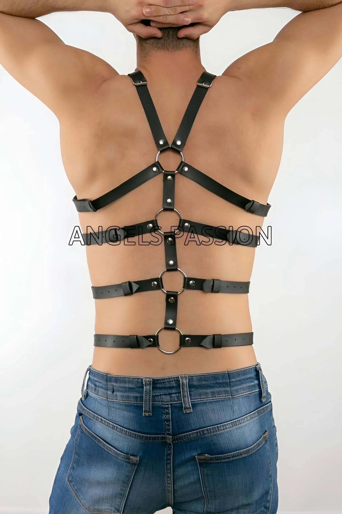 Black faux leather harness four horizontal bands worn shirtless over dark trousers side angle