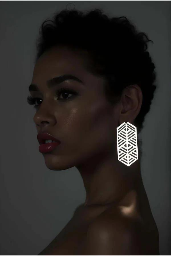 Beyaz lazer kesim reflektörlü geometrik küpe altıgen kafes desenli sarkık model kulakta