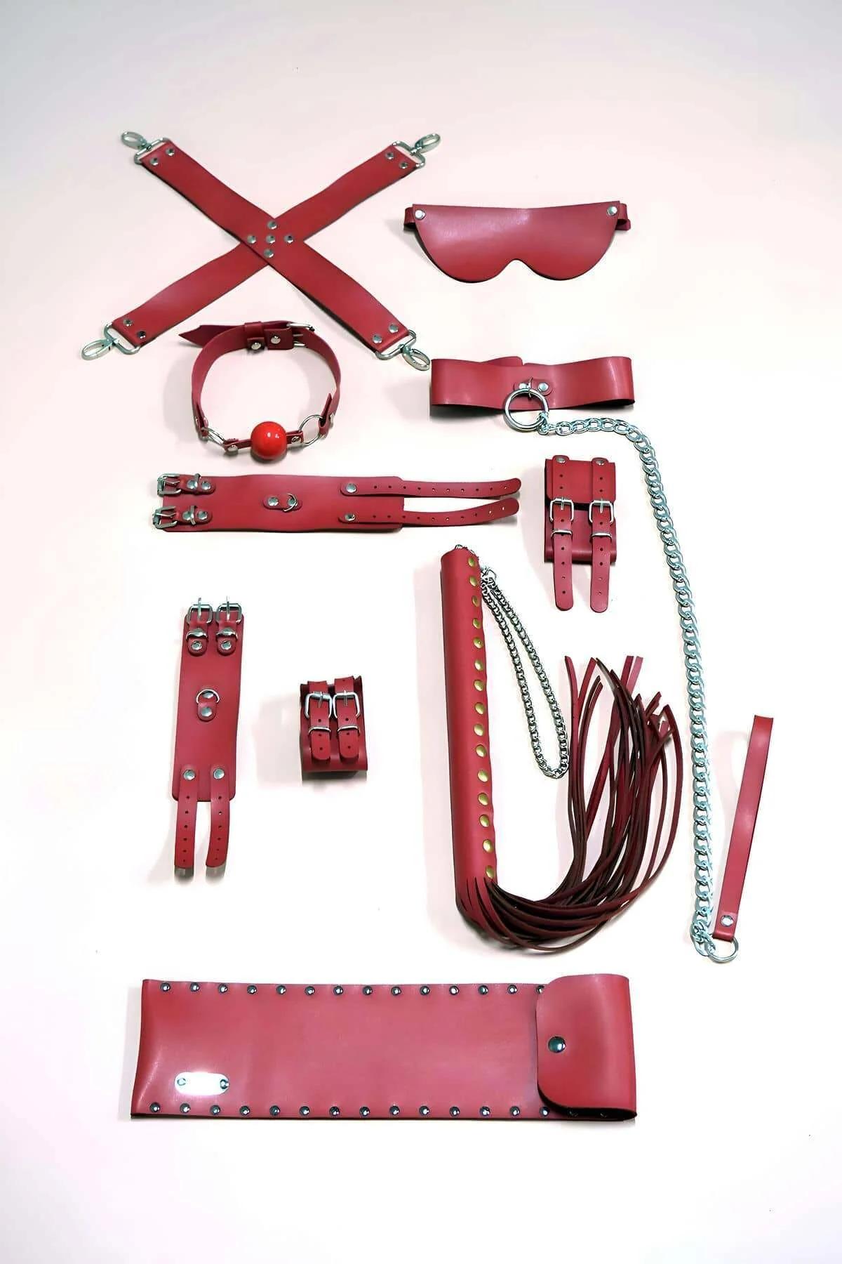 Red faux leather 9-piece accessory kit with silver snap hooks, studded waist belt, wrist cuffs, ankle cuffs, O-ring collar, c
